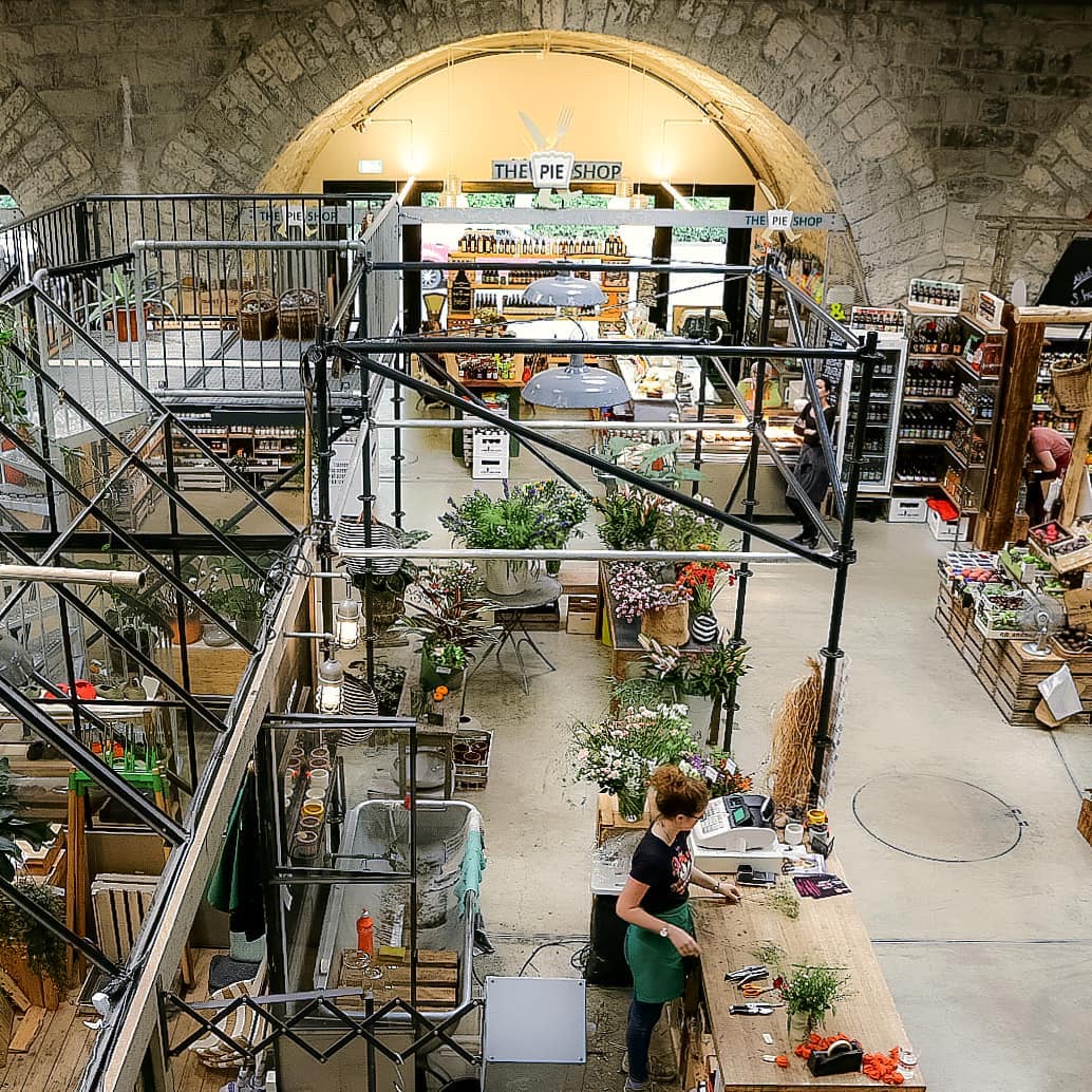 Lawatan makanan di Zürich Viadukt dengan gerai makanan berwarna-warni dan susunan bunga.