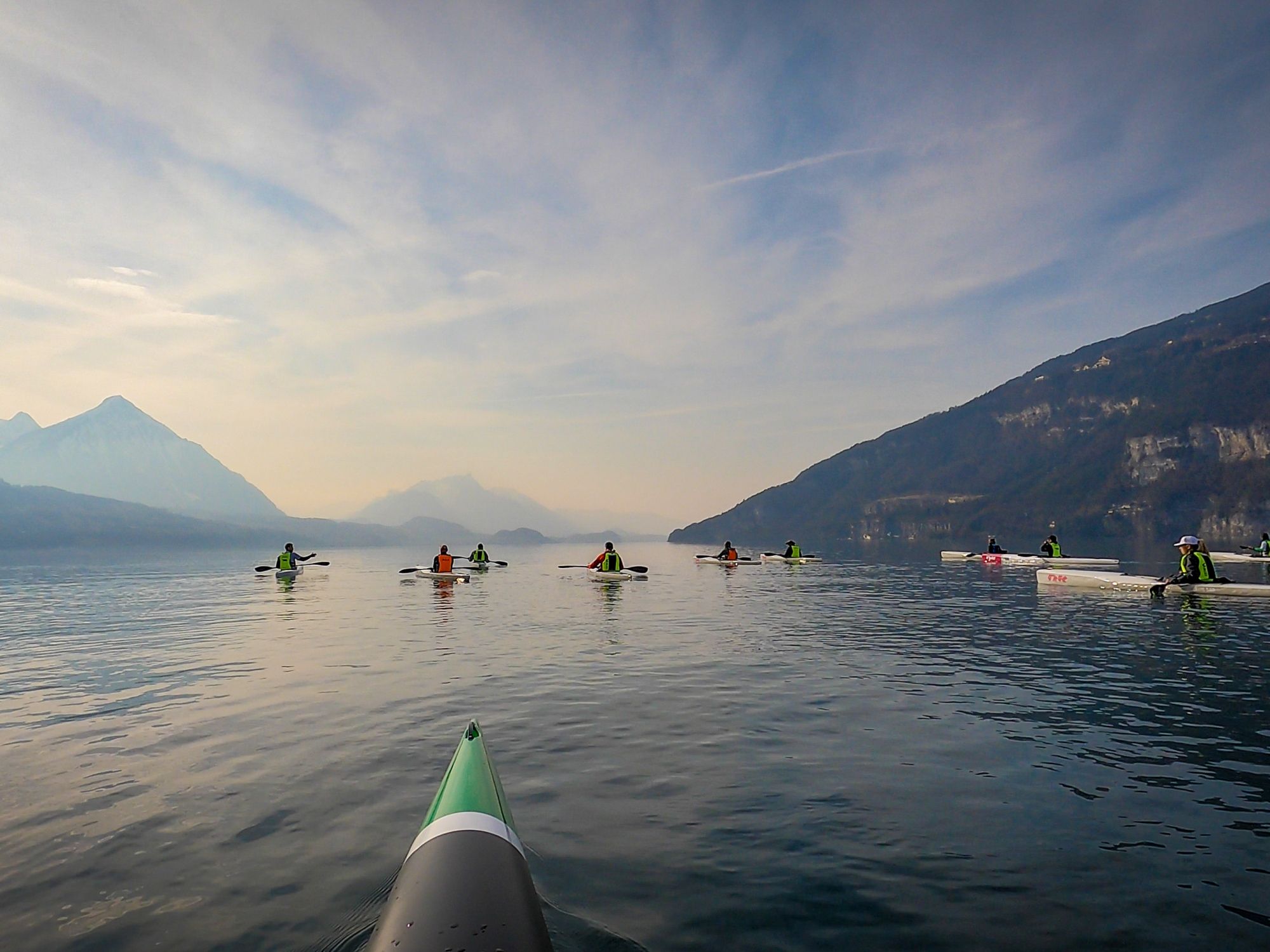 Surfski Basiskurs am Thunersee mit Wassersportlern und Bergen im Hintergrund.