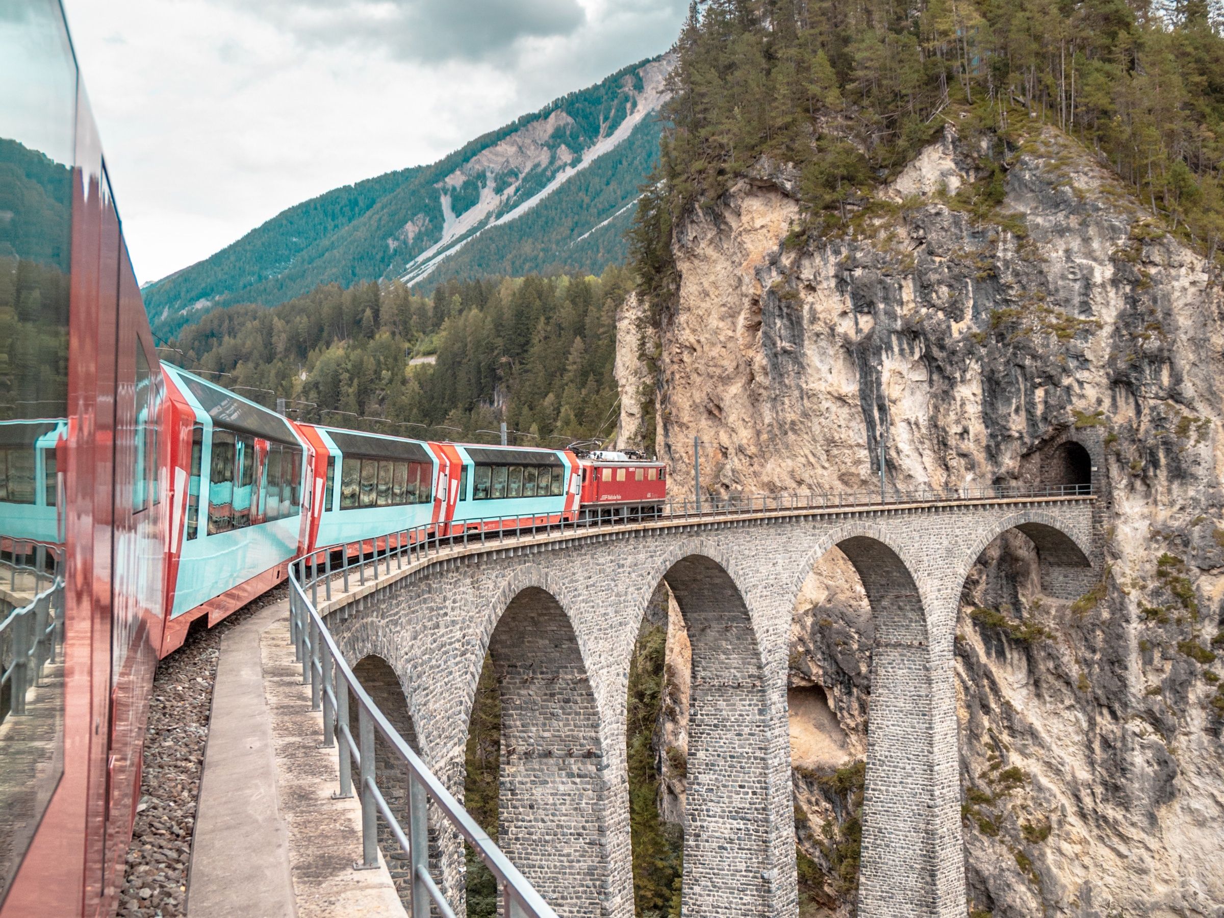 Glacier Express at the Landwasser Viaduct, impressive alpine landscape with train and rock formations.