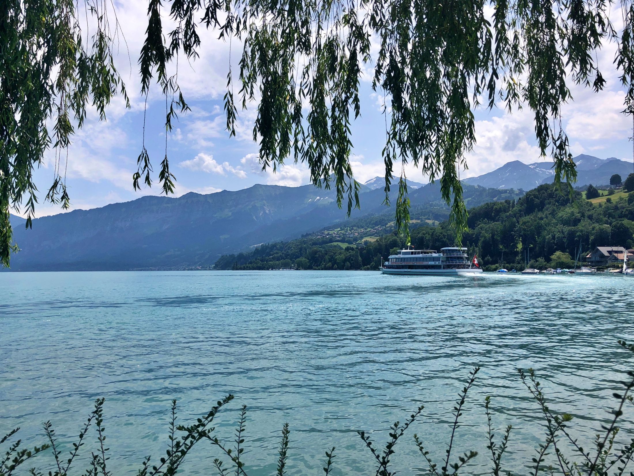 Thunermeer oever met bergen, boot en mooie natuur, ideaal voor ontspanning en recreatieve activiteiten.