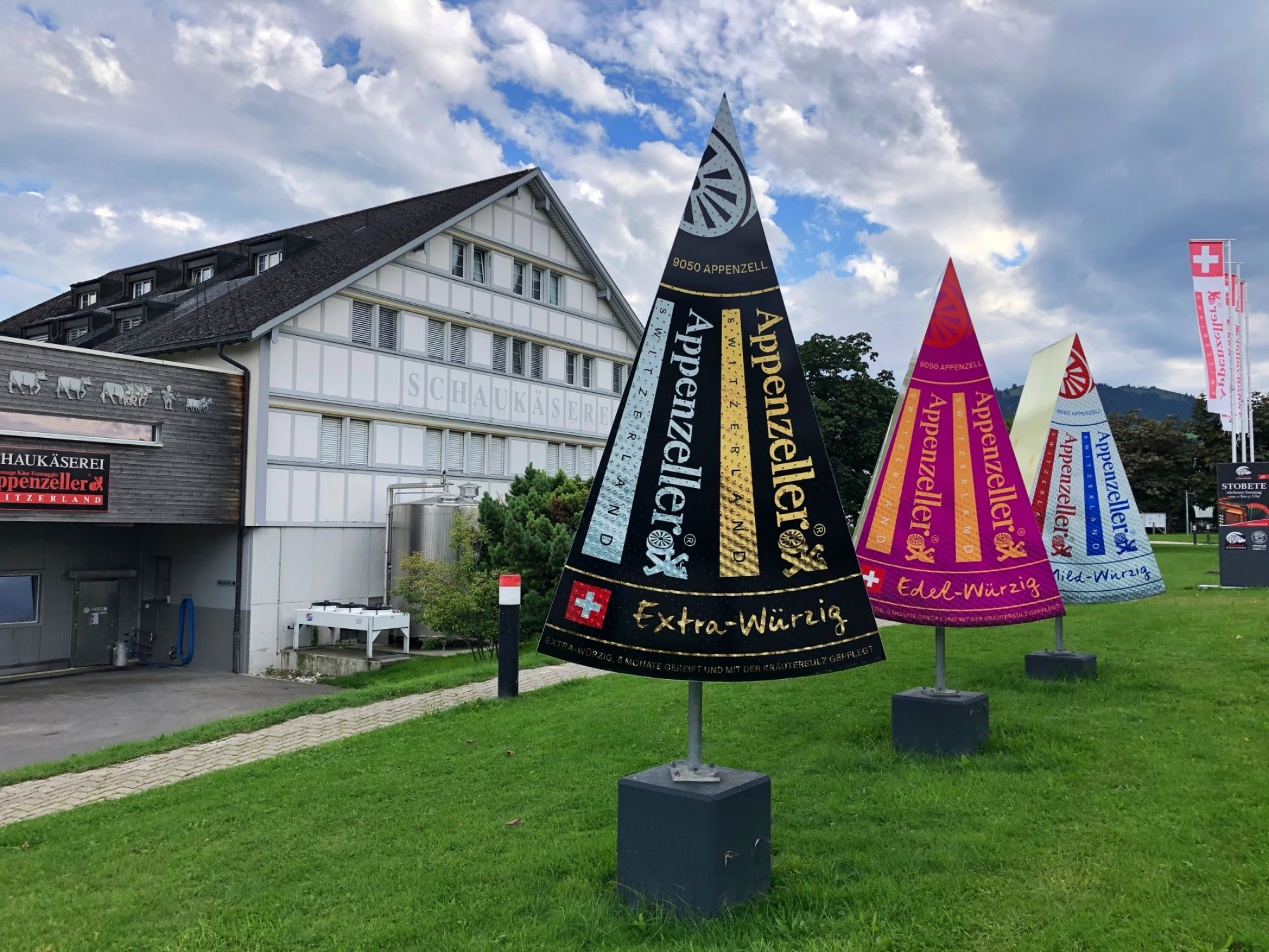 Appenzeller: Entdecke die Appenzeller Schaukäserei mit bunten Fahnen und Alpenpanorama.