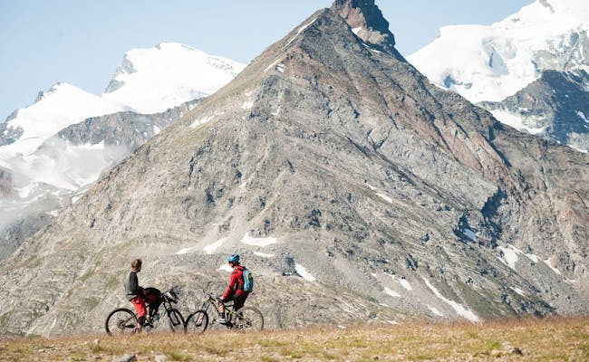 Jízda na kole na Kreuzbodenu ve Saas Fee s výhledem na hory.