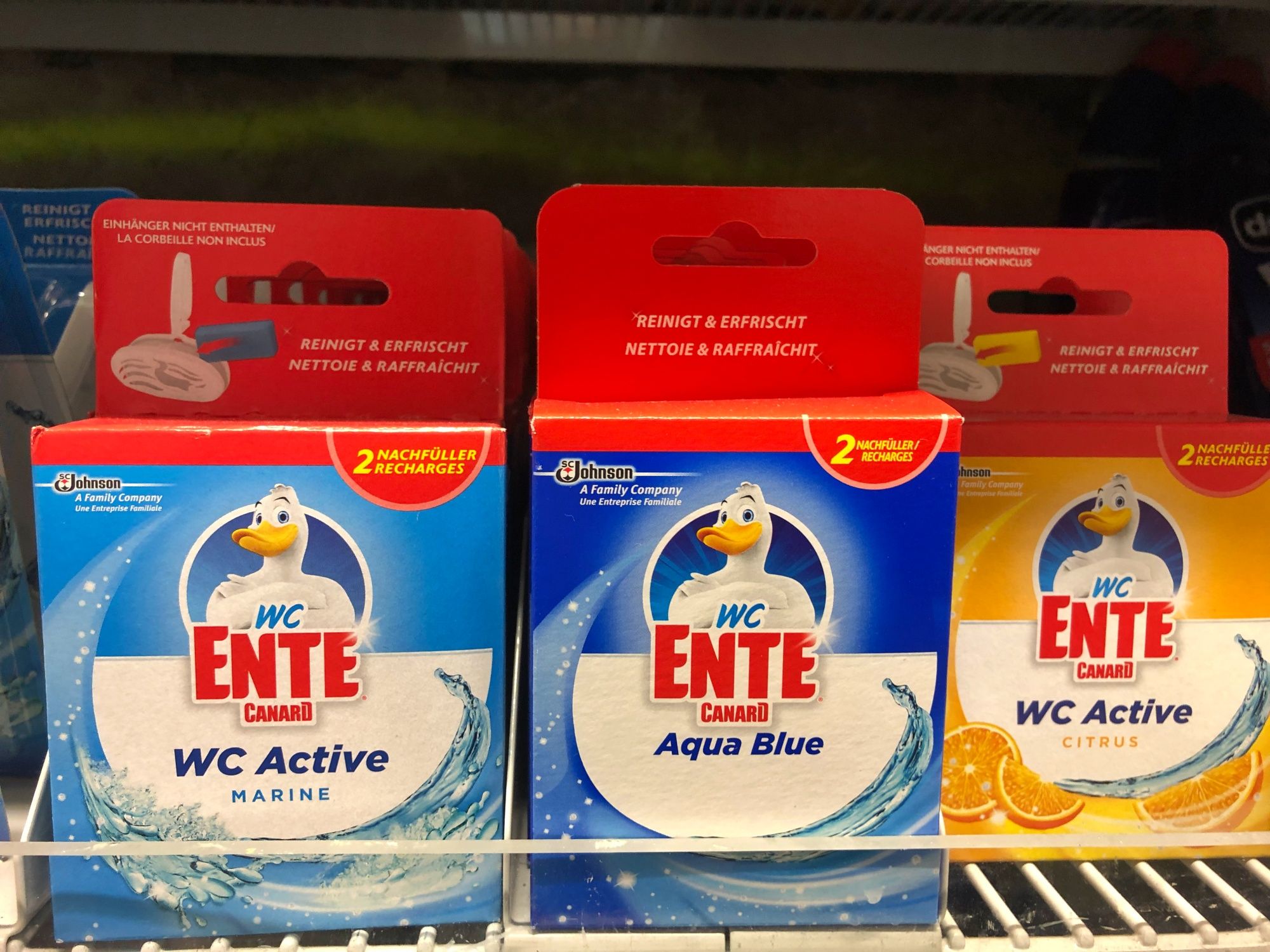 WCエンテアクアブルー、WCアクティブ、シトラスクリーニング剤が棚にあります。