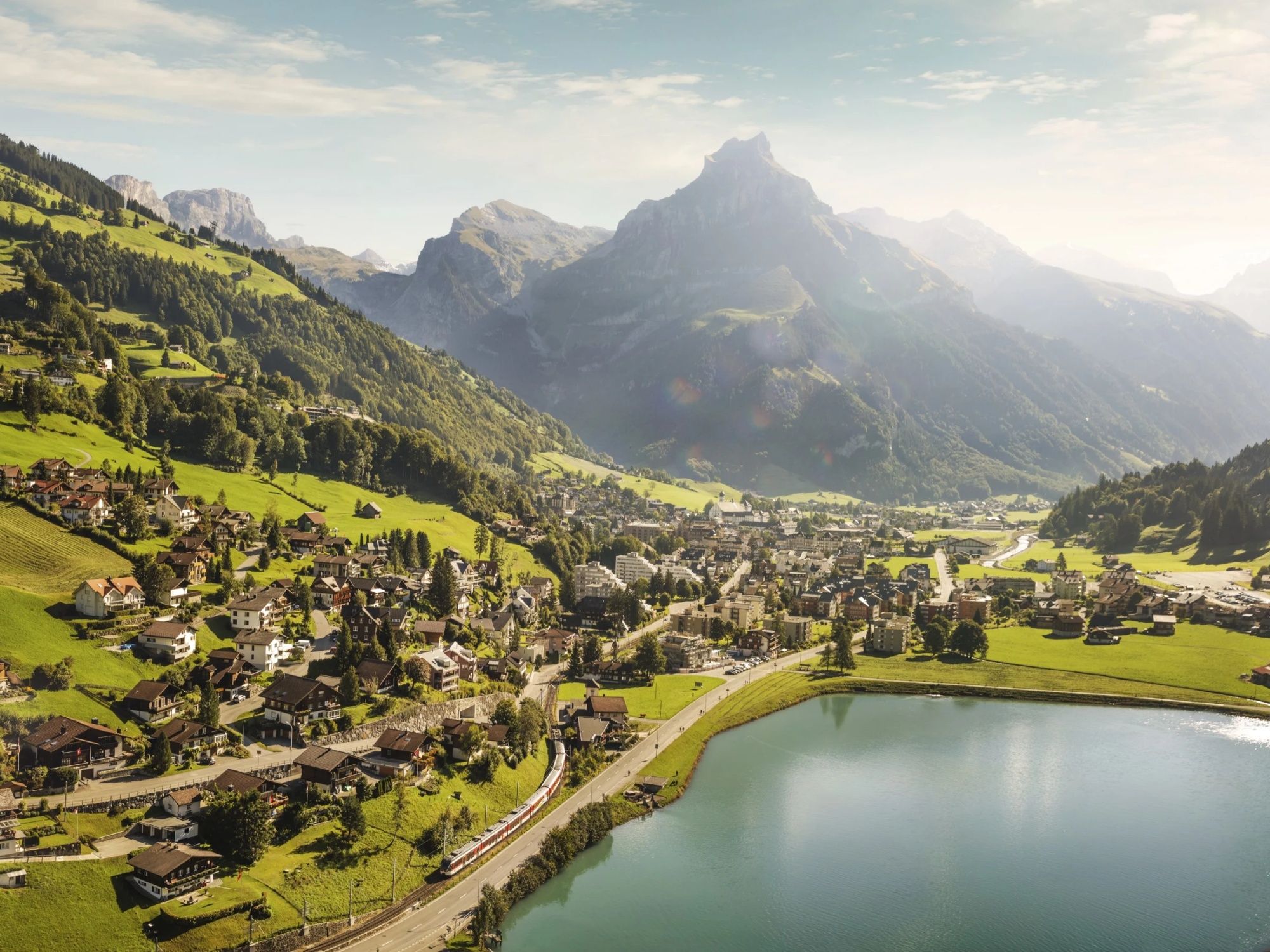 Golden Pass Line with train along Lake Walenstadt and green landscape.