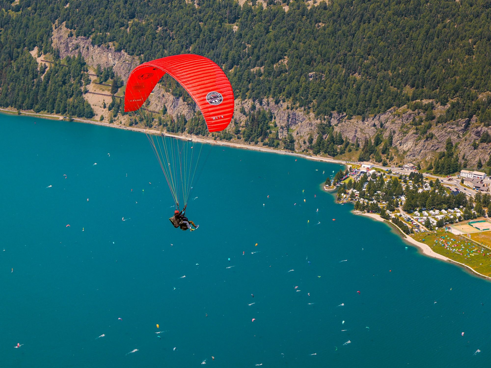 Gleitschirmfliegen in St. Moritz über dem Engadin mit spektakulärem Blick auf den See und die Berge.