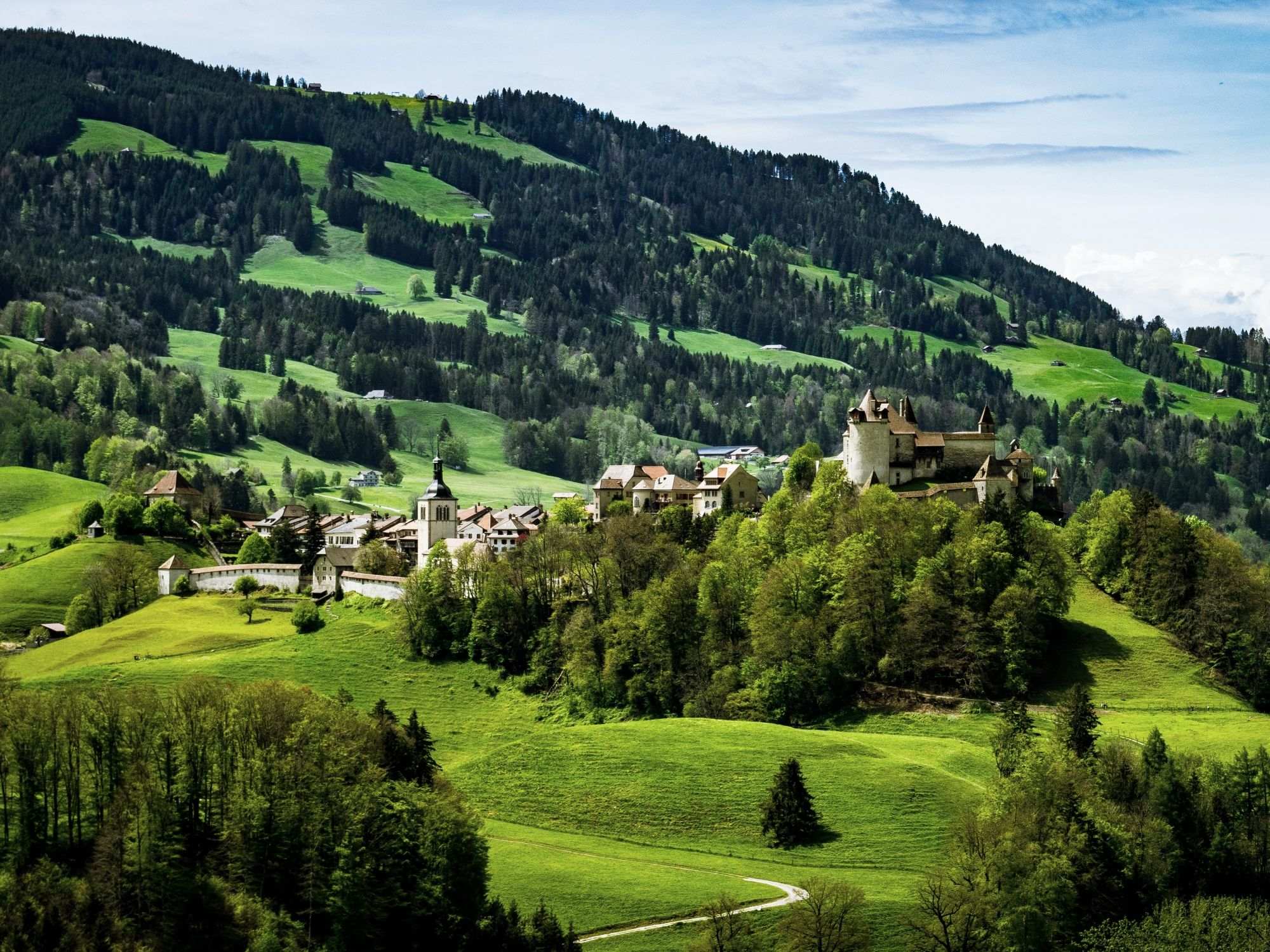 Gruyeres: impresionante paisaje con colinas verdes y arquitectura histórica en Suiza