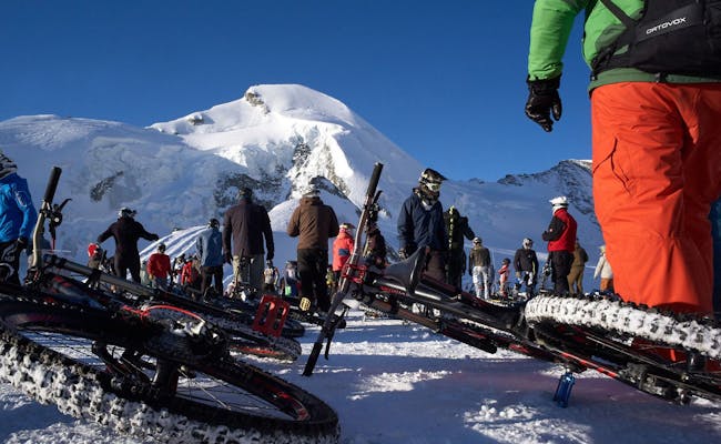 Masový start na kole po ledovci s účastníky na sněhu, Saas-Fee, 2023