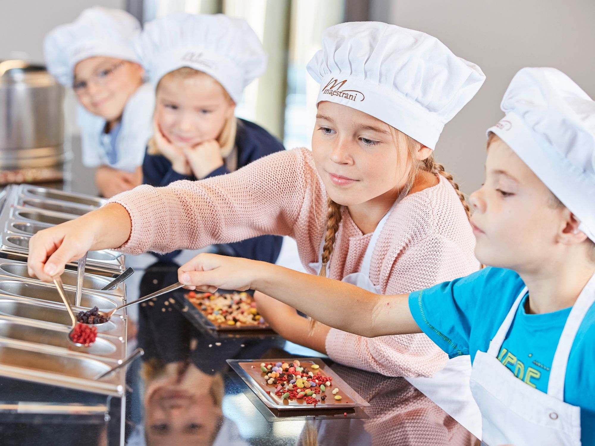 Décorer la table : Les enfants décorent de délicieuses friandises au Chocolarium Flawil.