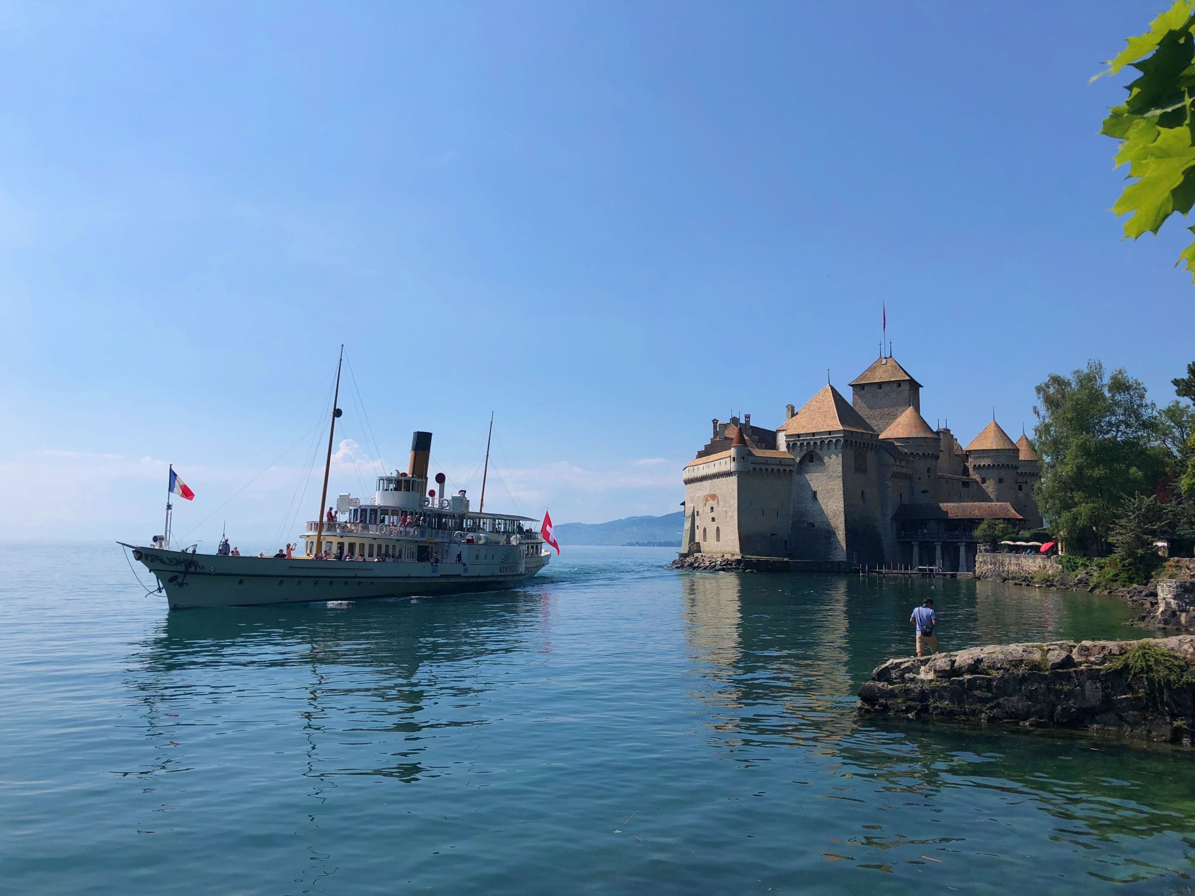 Chillon Castle with boat in Lake Geneva in summer