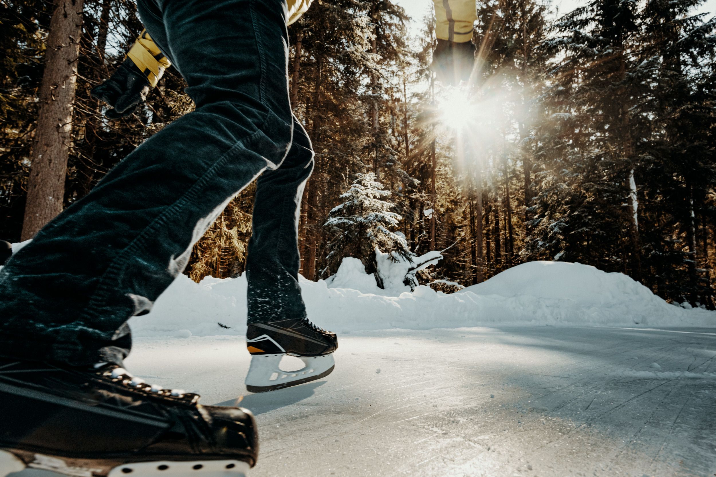 Bruslení na přírodní ledové dráze v zimě s stromami.