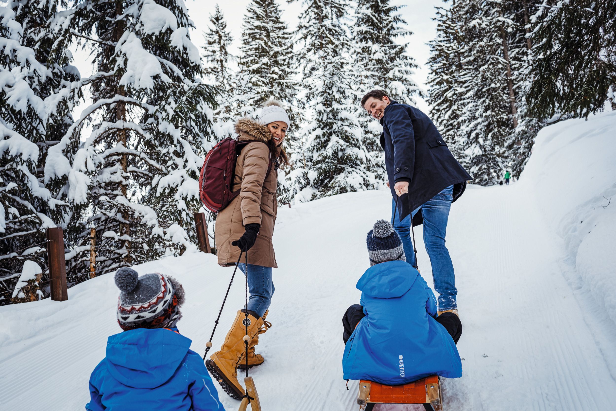 Rodina na sáňkách ve sněhu, lesní prostředí, zimní počasí