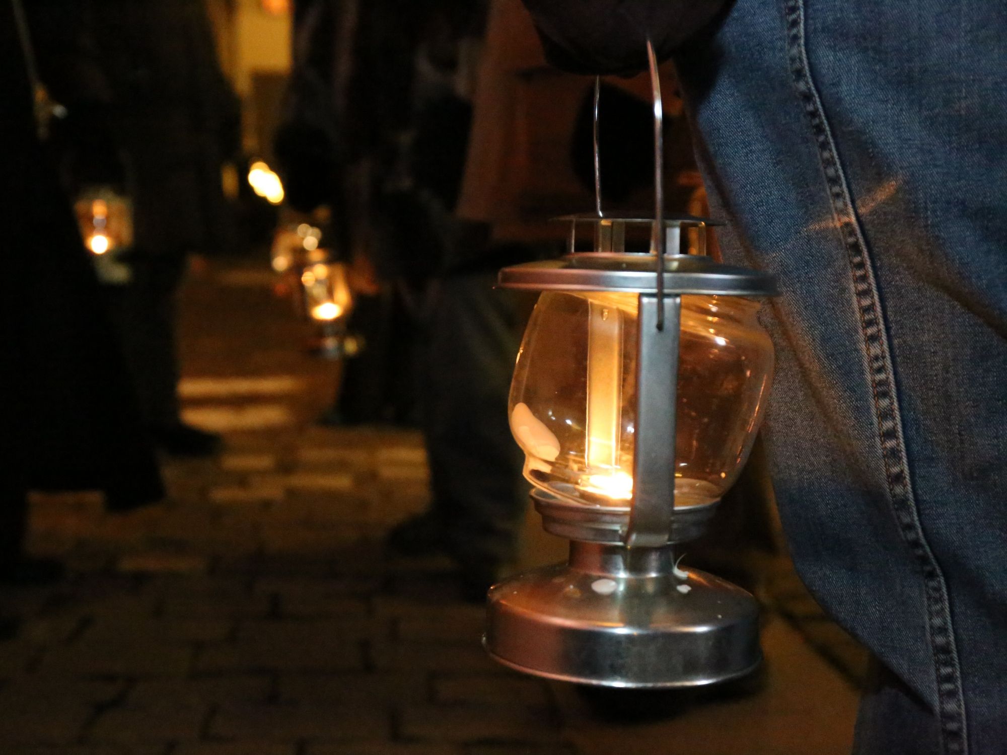 Zwiedzanie miasta Chur z latarnią w ręku nocą.