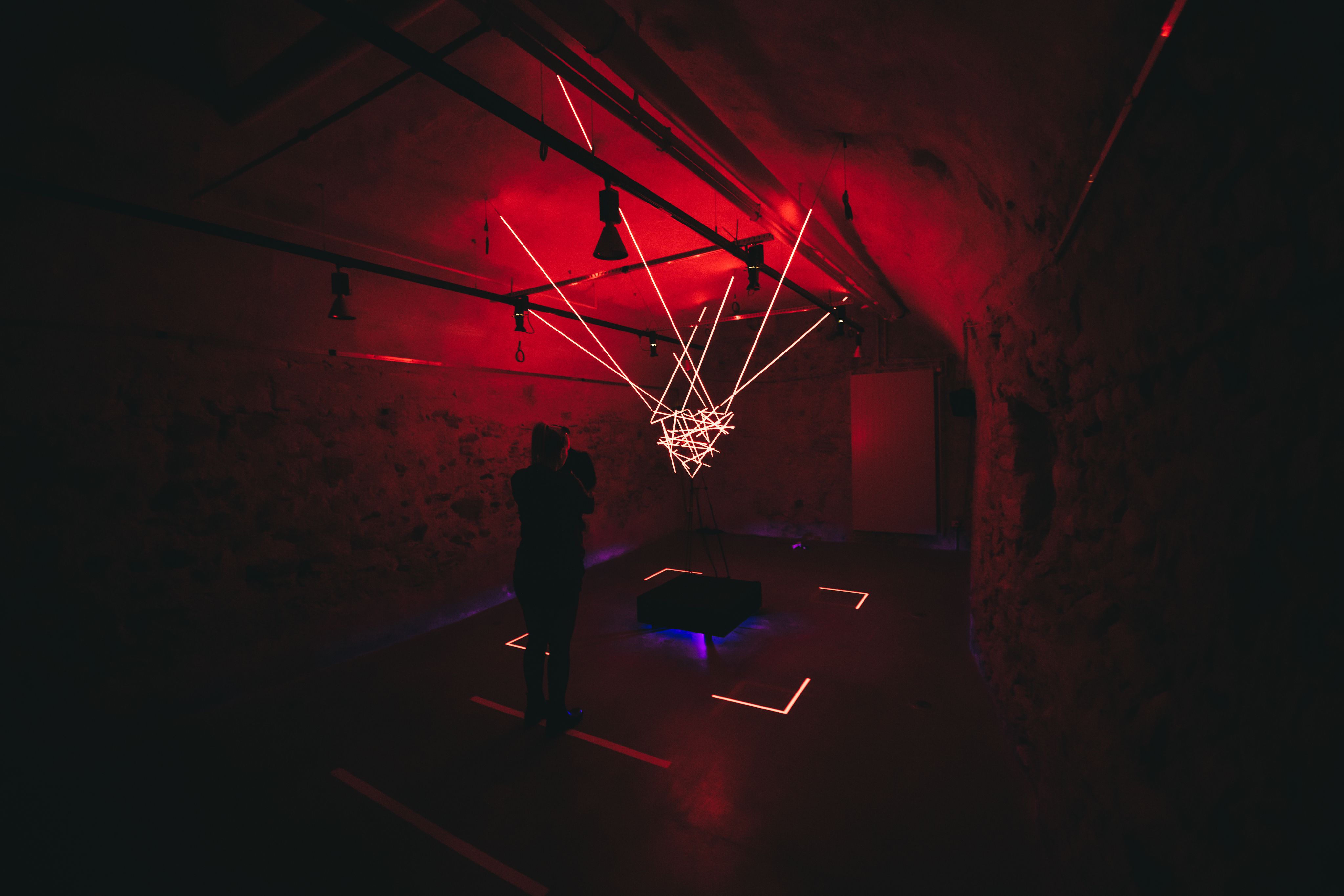 Murten Circuit Hemmelighed viser en kunstinstallation med neonlys, der oplyser rummet.