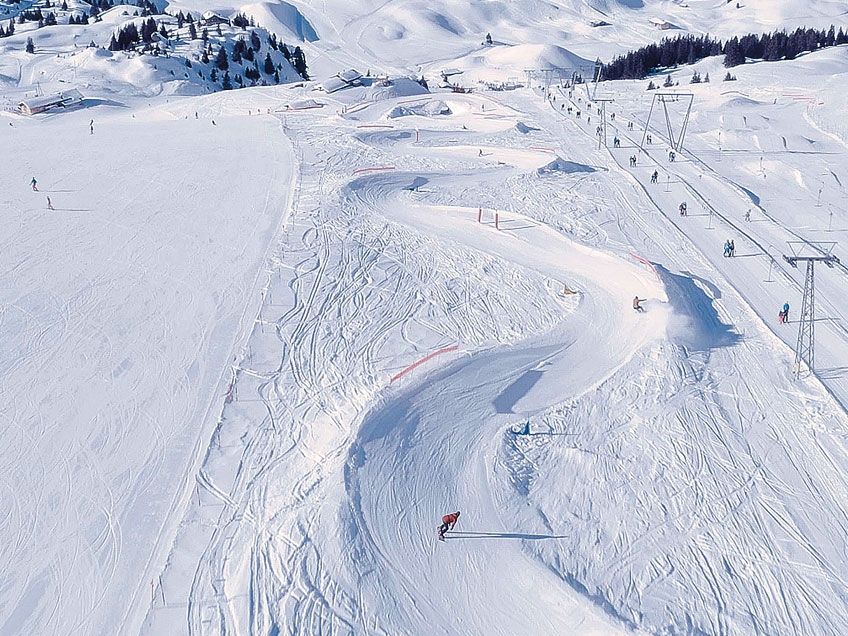 Estação de Esqui Elsigen Metsch com esquiadores na pista na neve