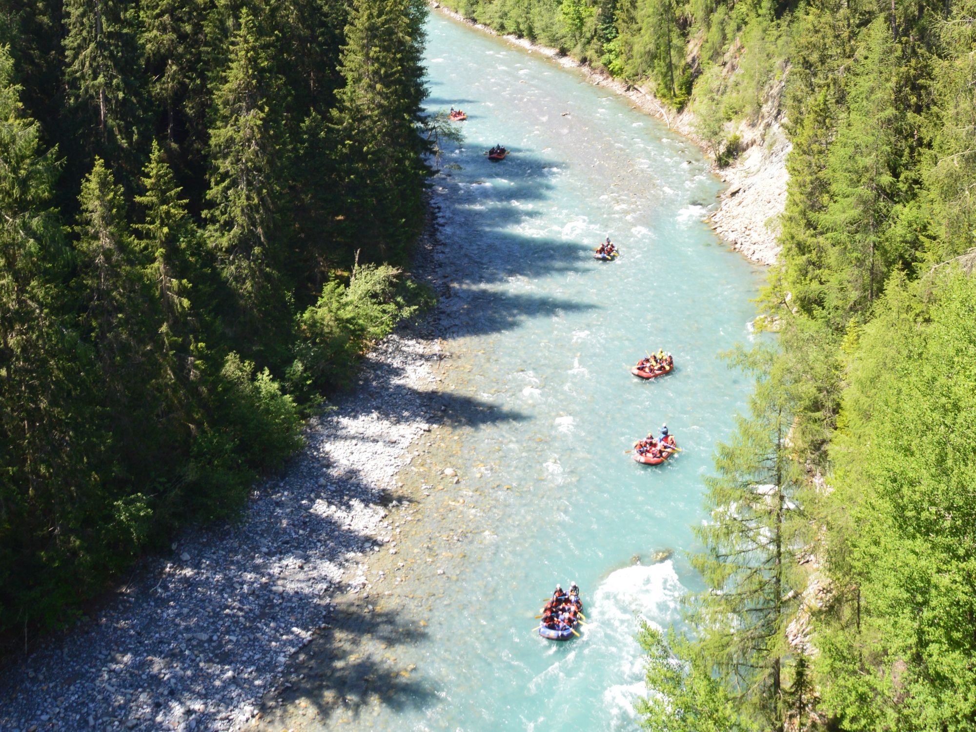Rafting di Lembah Scuol: alami perjalanan penuh pengembaraan di antara hutan dan sungai.