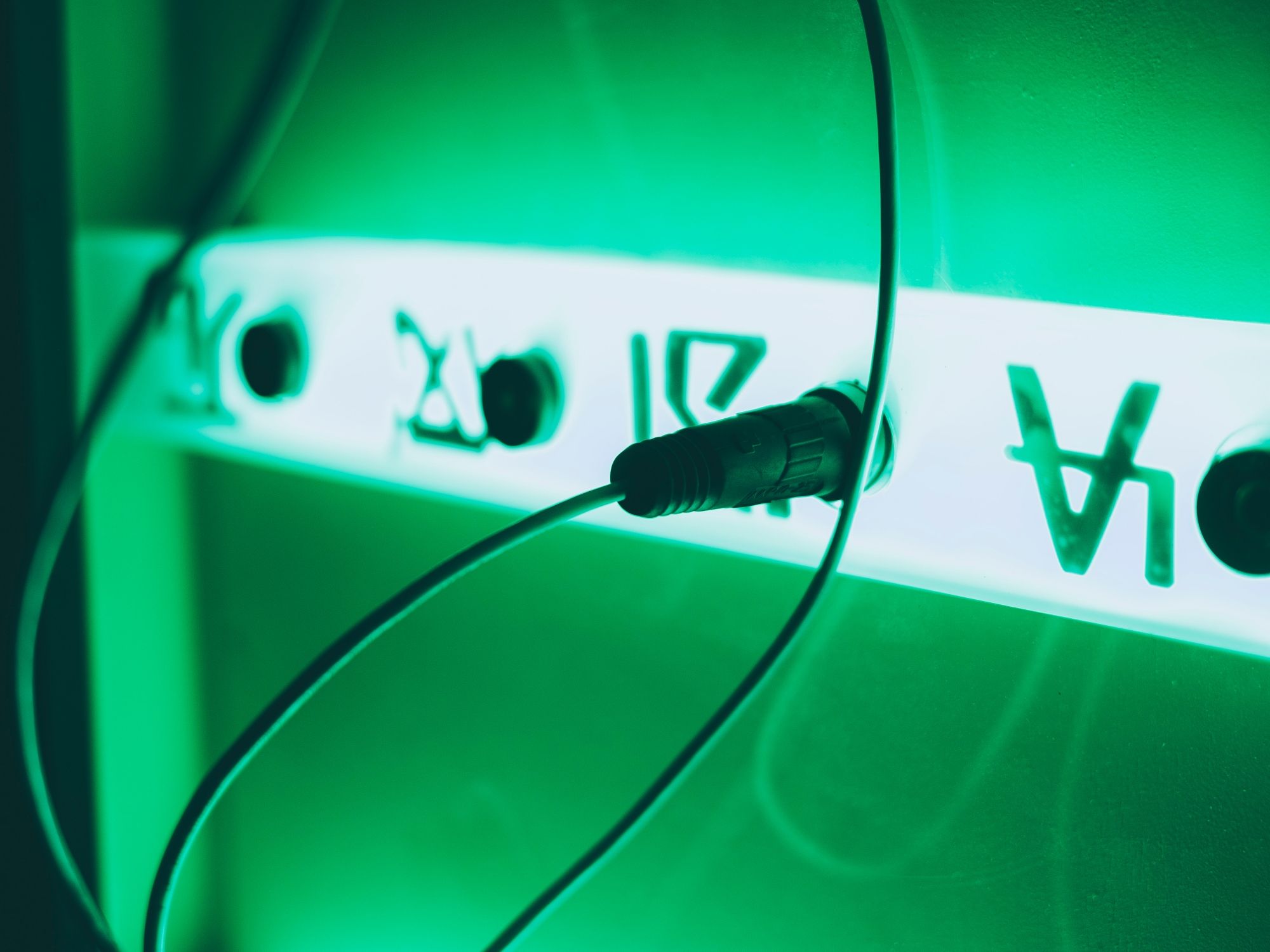 Escape Room Lucerne: spændende atmosfære med grønne lys og kabler til et uforglemmeligt eventyr.