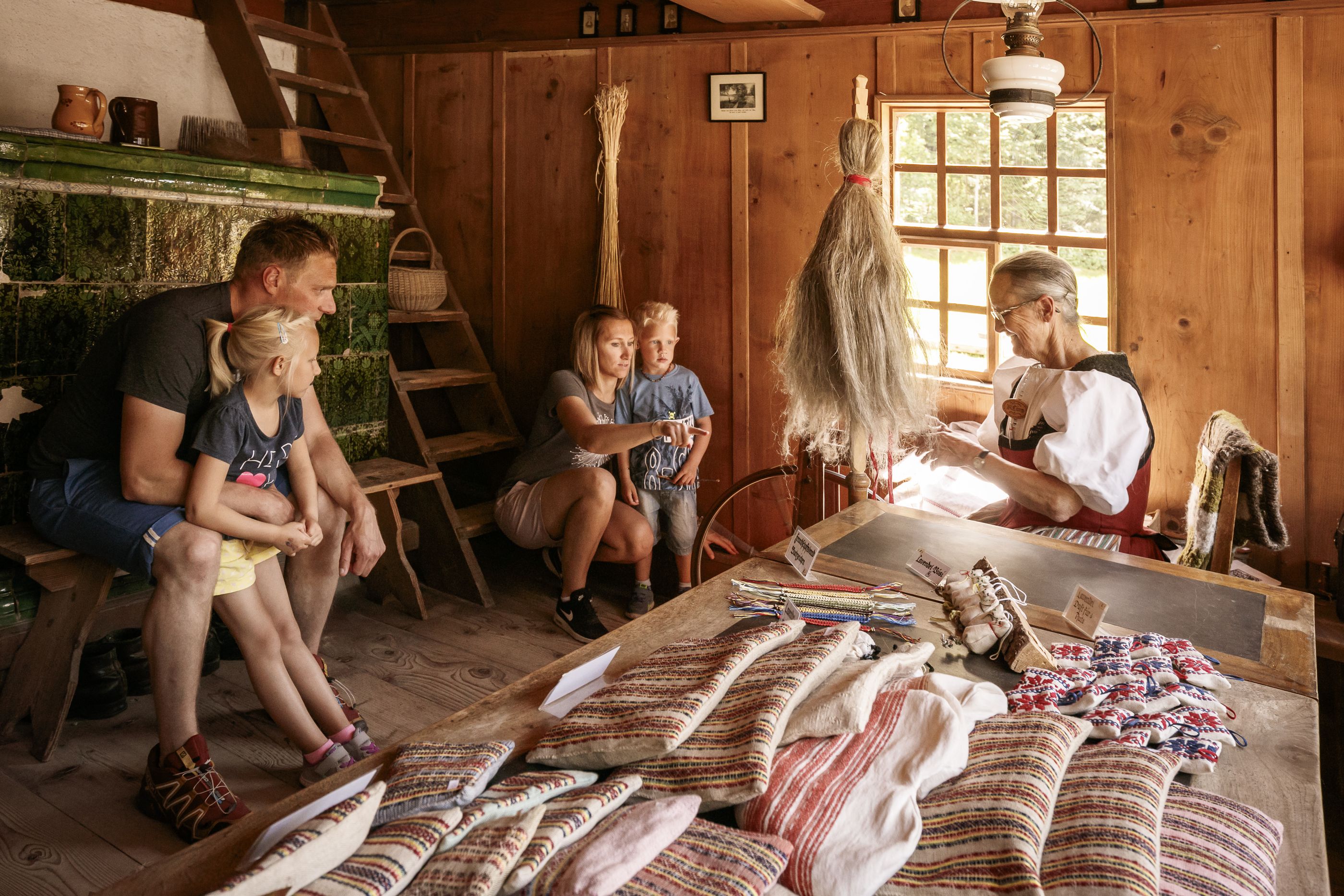 在巴伦贝格露天博物馆观察蜘蛛，家庭在旁观看，传统技巧