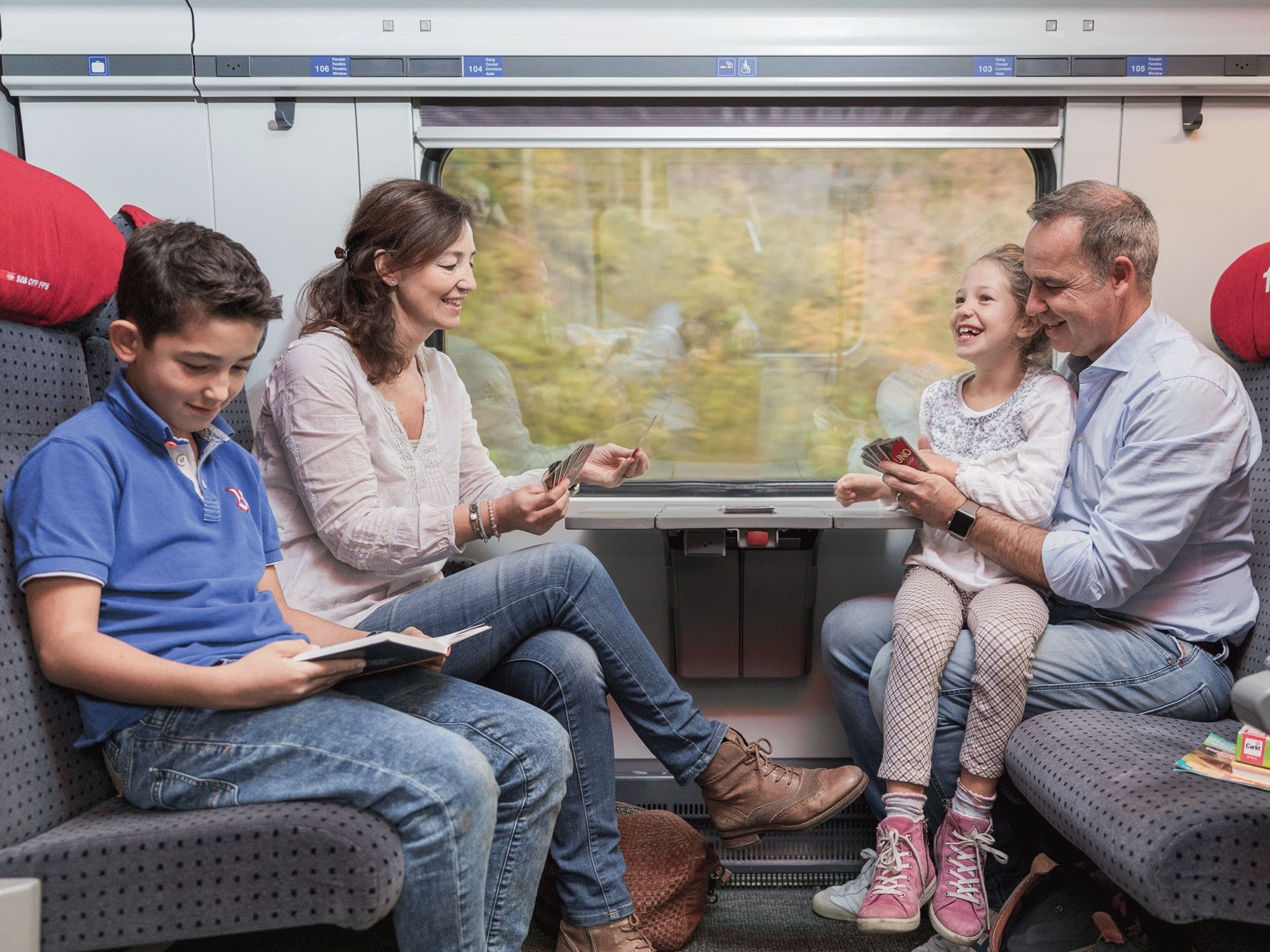Perjalanan Kereta: Keluarga menikmati pemandangan di kereta saat menjelajahi lanskap Swiss.