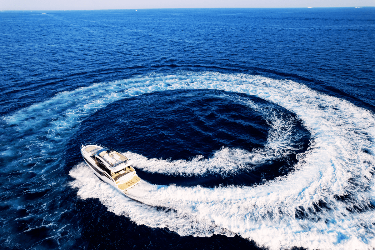 याच्ट: प्रभावशाली नीली महासागर में एक शाही मोटरयाच्ट शाम को शानदार वर्तुल बनाते हुए