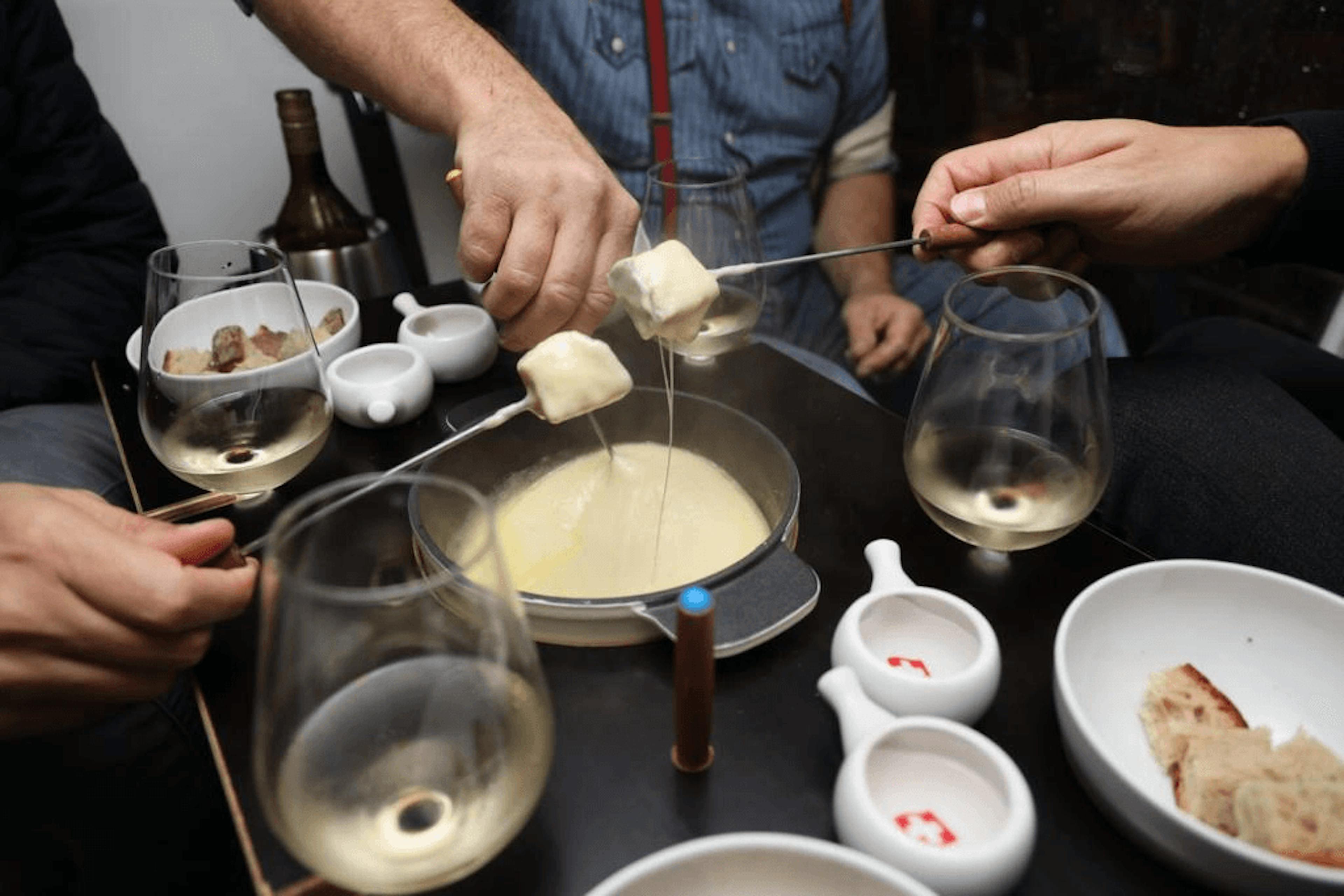 Fondue : plaisir entre amis lors de l'aventure d'hiver, fondue au fromage et moments conviviaux.