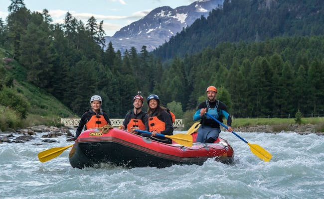 Rafting w Engadynie z grupą na rzece, otoczony górami i lasami.