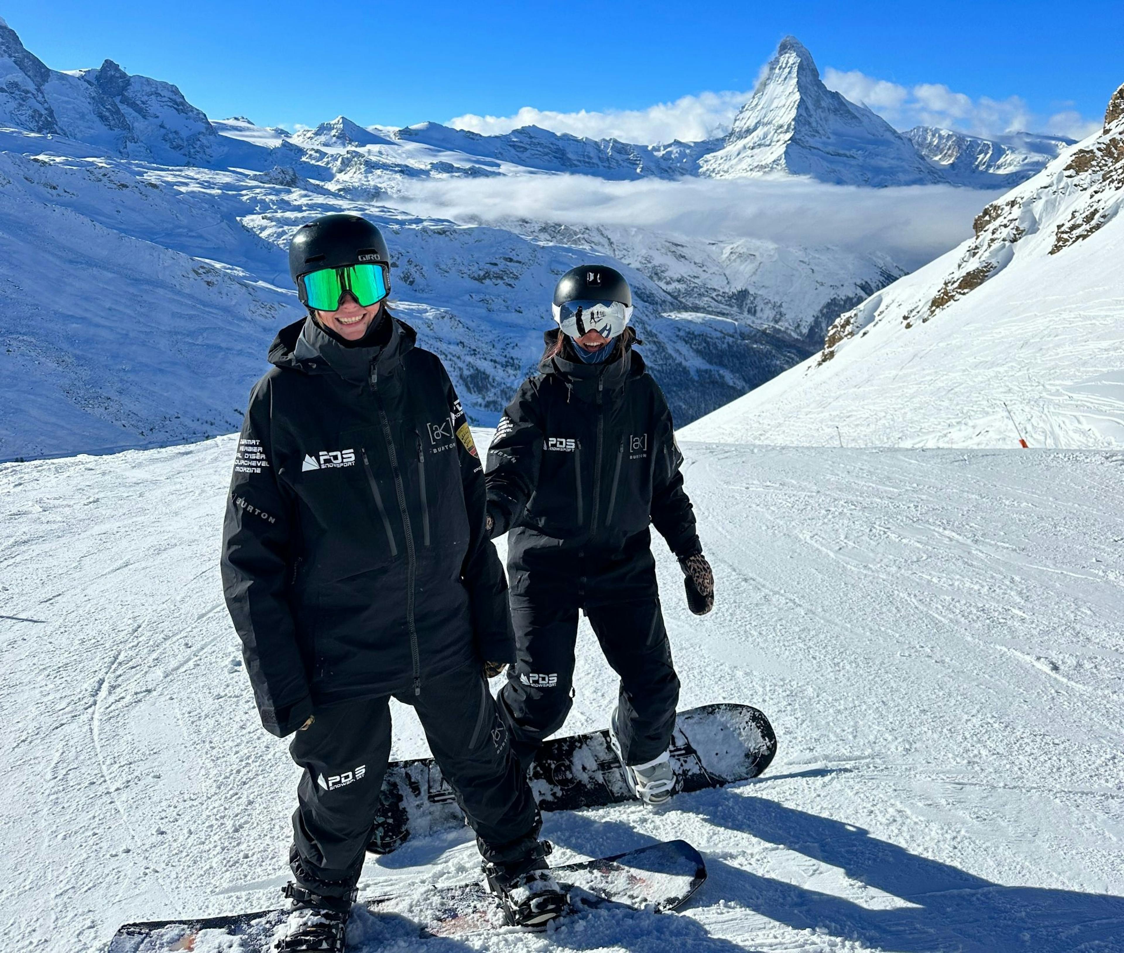 Cours de snowboard avec des snowbordeurs devant le Cervin dans un paysage d’hiver magnifique.