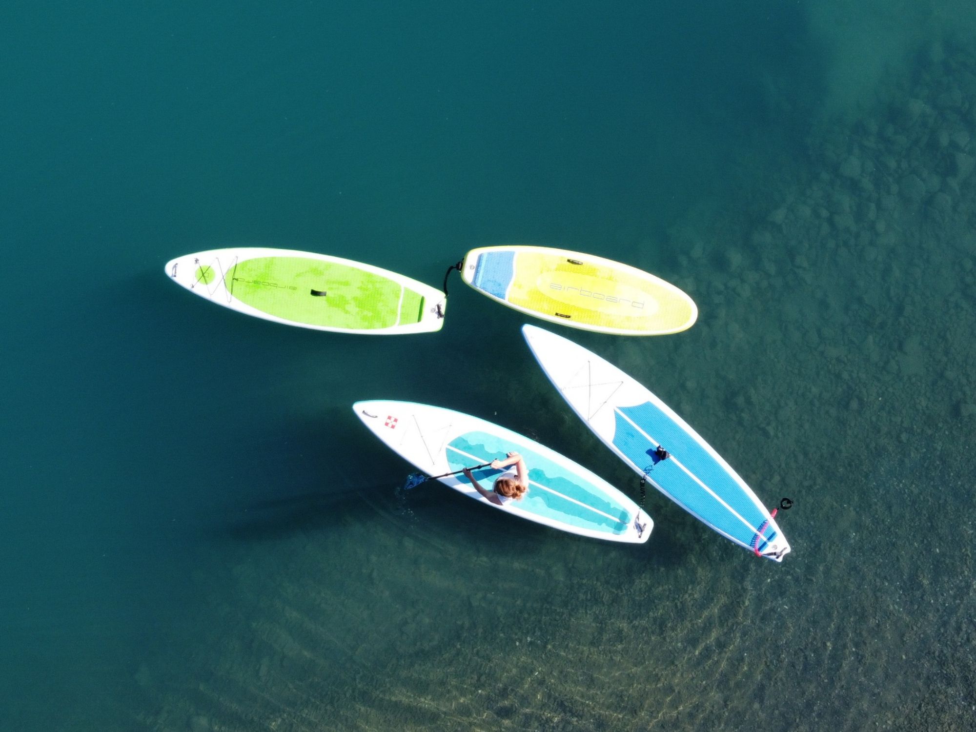 SUP na jezeře Brienz s přáteli, uvolňující vodní sporty na modré vodě.
