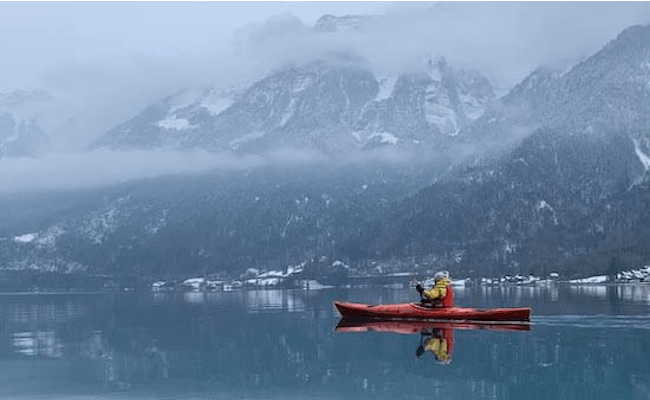 Kajak på Brienzersee om vinteren omgivet af snedækkede bjerge.