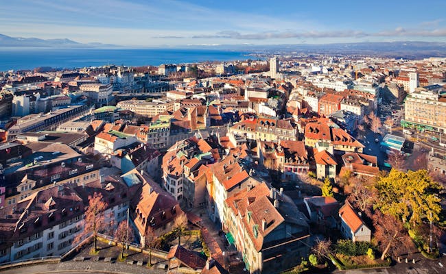 Lausana: Privire asupra orașului cu cer albastru, soare, lac și clădiri istorice