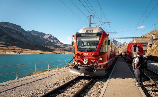 Bernina Express en Ospizio-Bernina con hermosas montañas y agua clara, ideal para los amantes del ferrocarril.