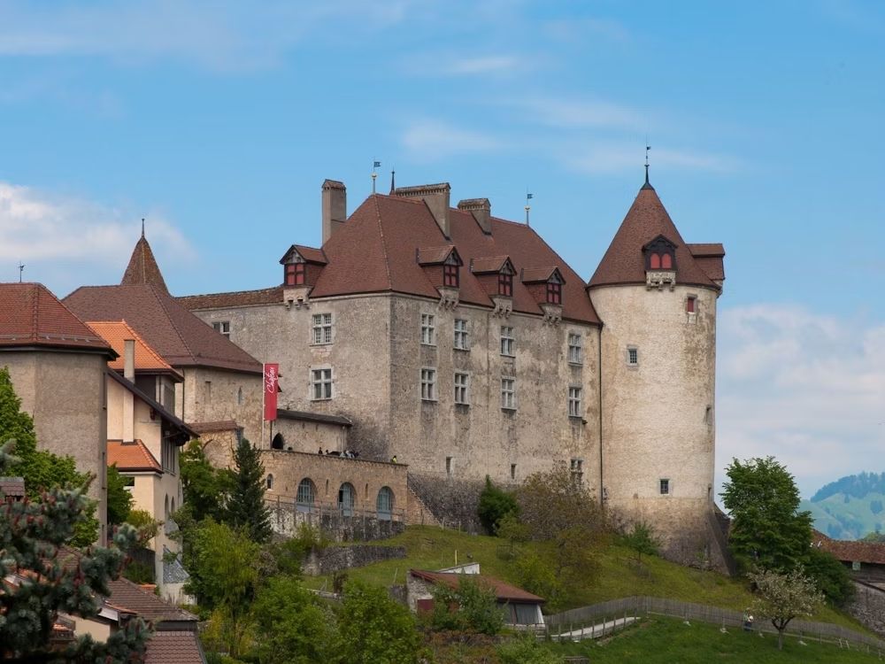 Istana Gruyères: bangunan bersejarah dikelilingi oleh alam hijau dan Alps Swiss.