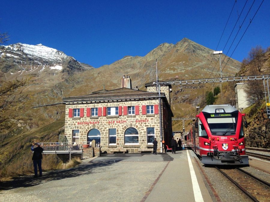 Ospizio Bernina: Stationsgebouw met uitzicht op de berg en trein in de zomer, ideaal om te reizen.