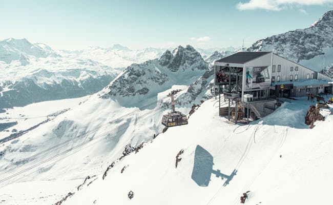 Mountain station near St. Moritz in winter, breathtaking landscape with snowy mountains and cable car.