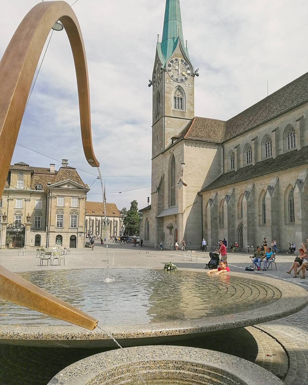 น้ำพุในย่านเก่าเมืองซูริคพร้อมบ่อน้ำและอาคารรอบข้าง