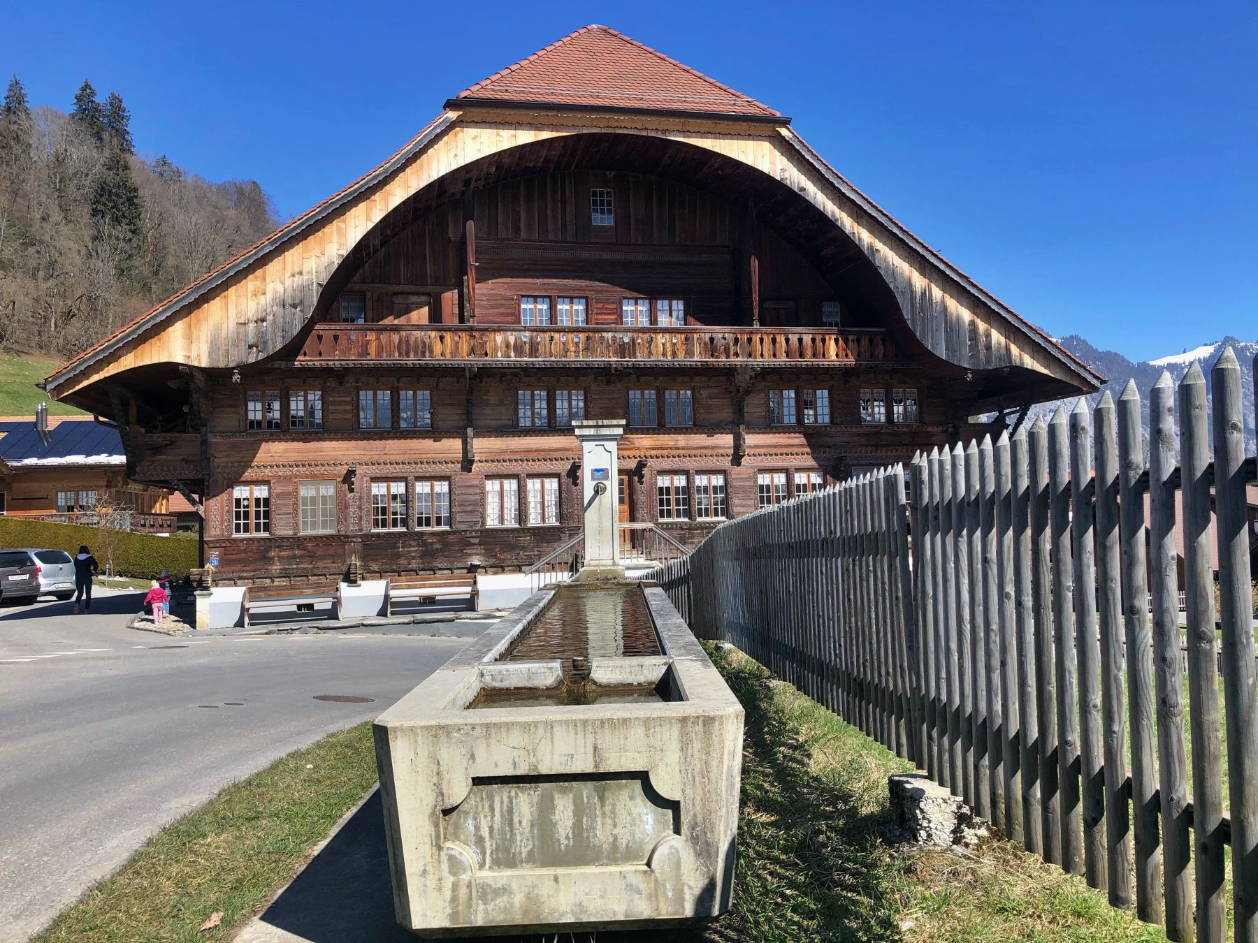 Air minuman Switzerland Sumur bersebelahan rumah kayu di alam semula jadi.