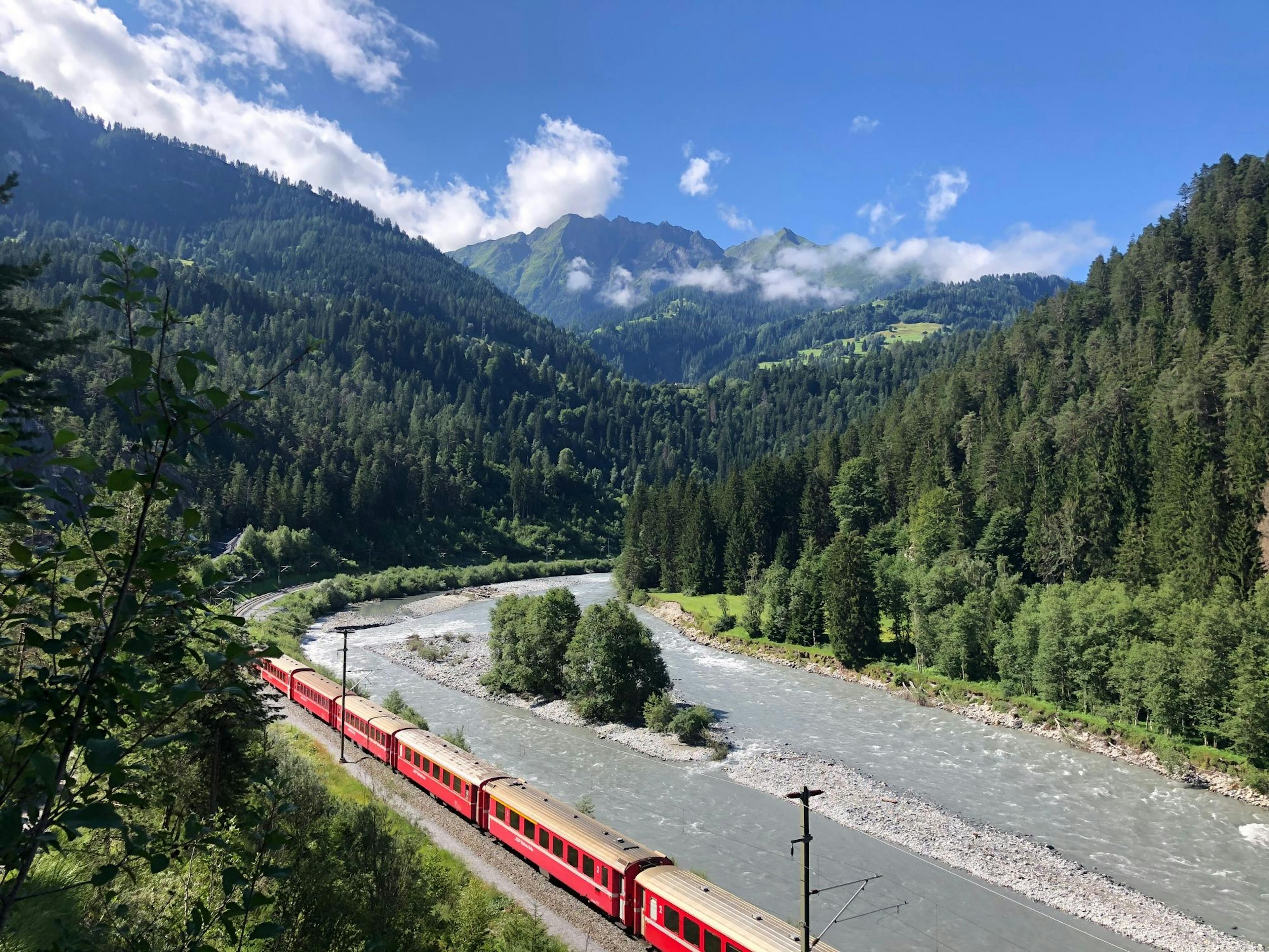 火车穿过多洛米蒂,夏天被森林和山脉环绕。