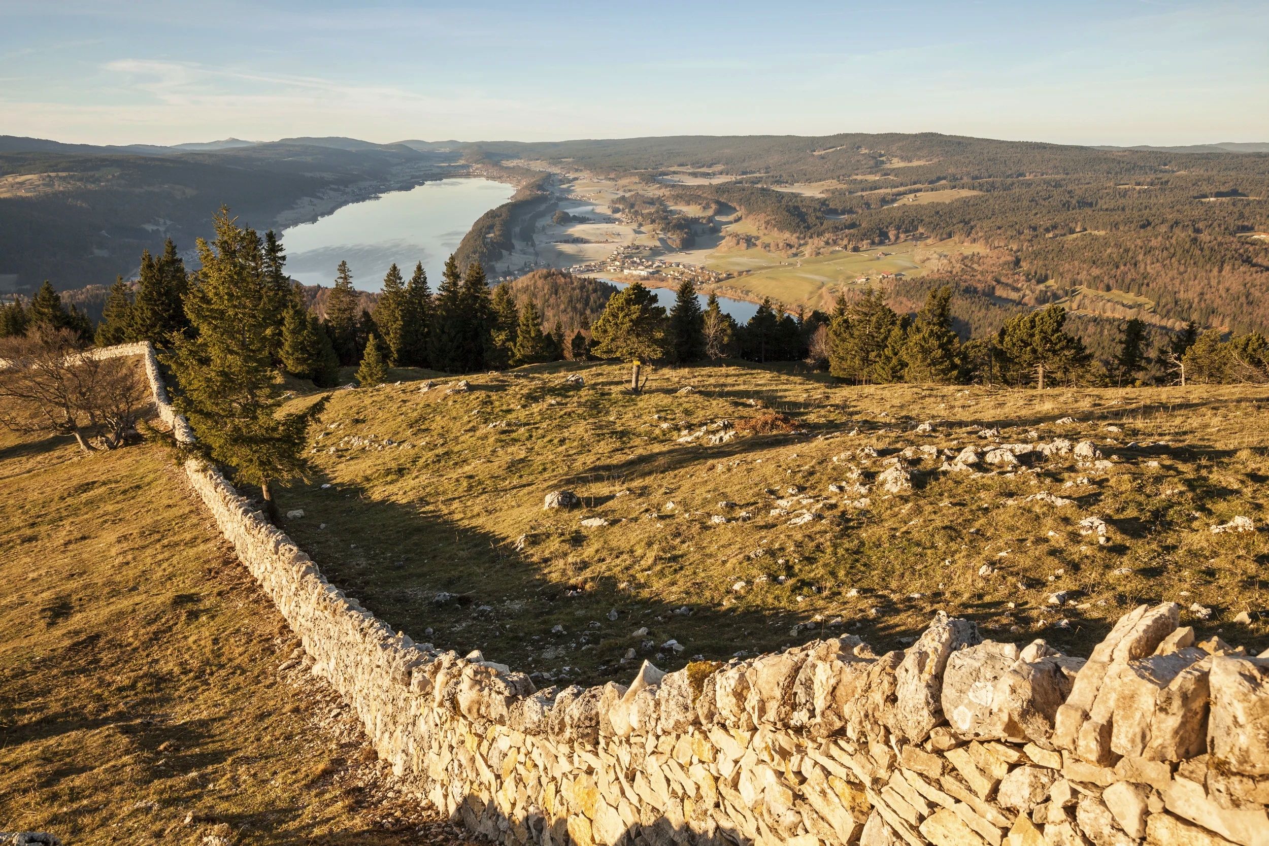 Vista Dent de Vaulion: Panoramica su colline, boschi e acqua durante un'escursione in Svizzera.