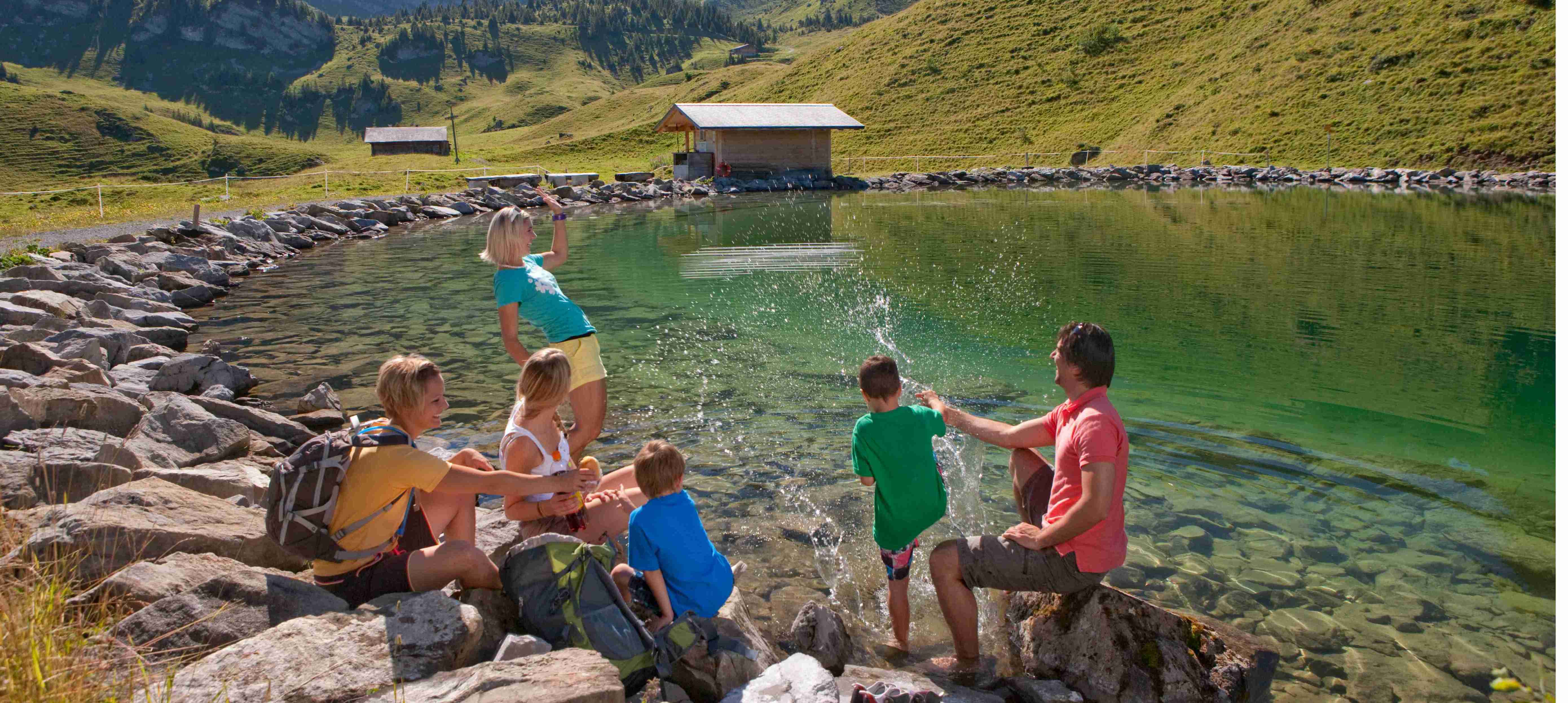 Brandsee Elsigen-Metsch com crianças e adultos a banhar-se na margem.