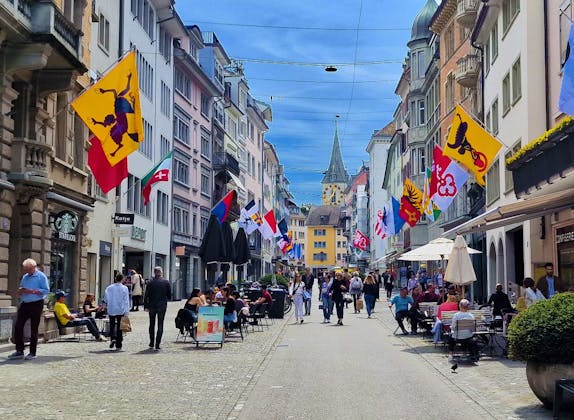 City Tour: Experience Zurich with colorful flags and lively street cafes in summer.