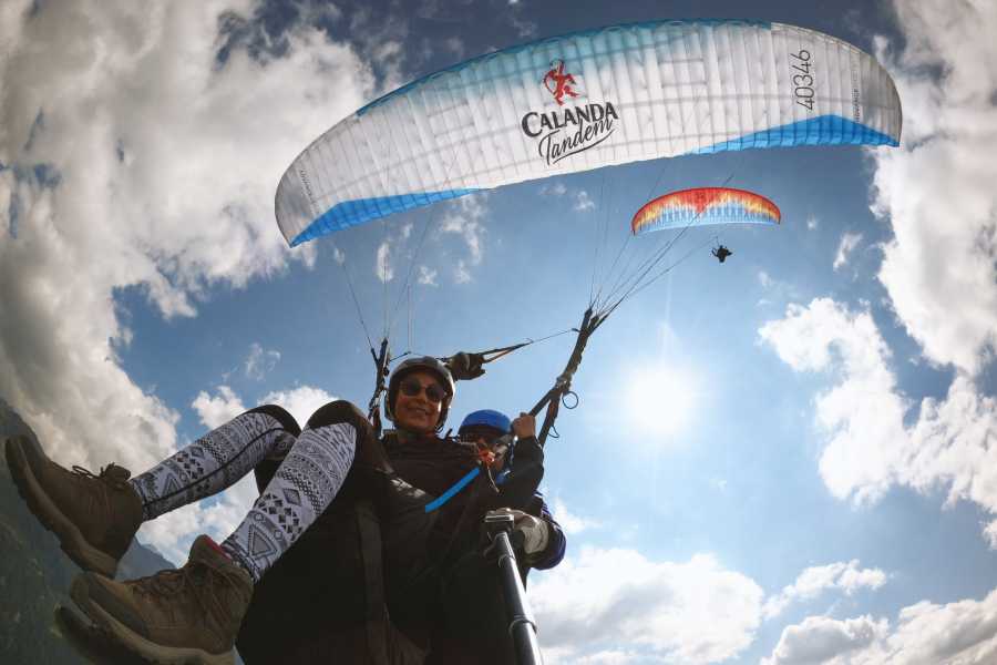 Early Bird Paragliding: Genieße das Gleitschirmfliegen in Davos unter strahlendem Himmel.