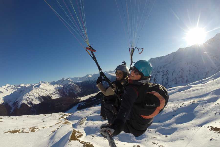 Paragliden in Klosters: Uitzicht op besneeuwde bergen en spannende avonturen in het winterlandschap.