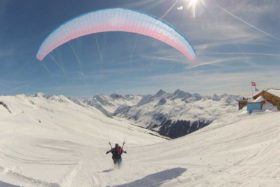 Vuelos en parapente sobre los Alpes cubiertos de nieve con un iglú de fondo, ideal para aventuras en la naturaleza.