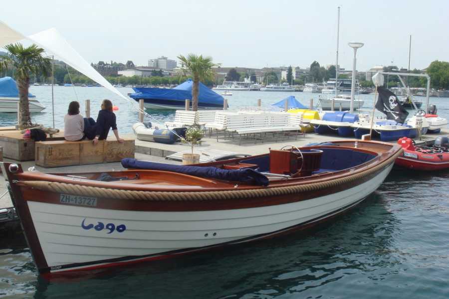 Sporte uji në Liqenin e Cyrihut me anije dhe palma.