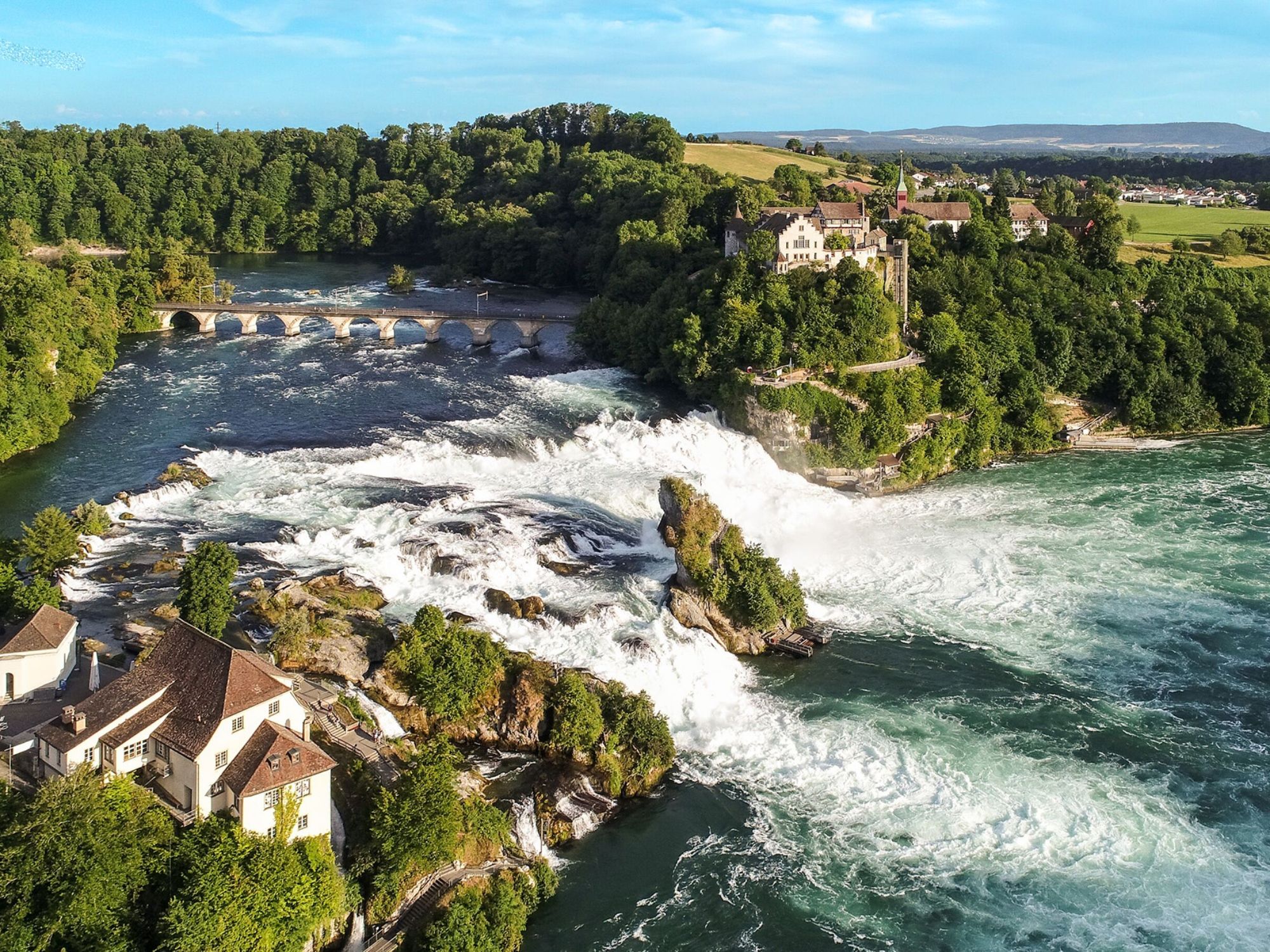 Rhine Falls: impressive waterfalls on a tour from Zurich, surrounded by nature and green hills.