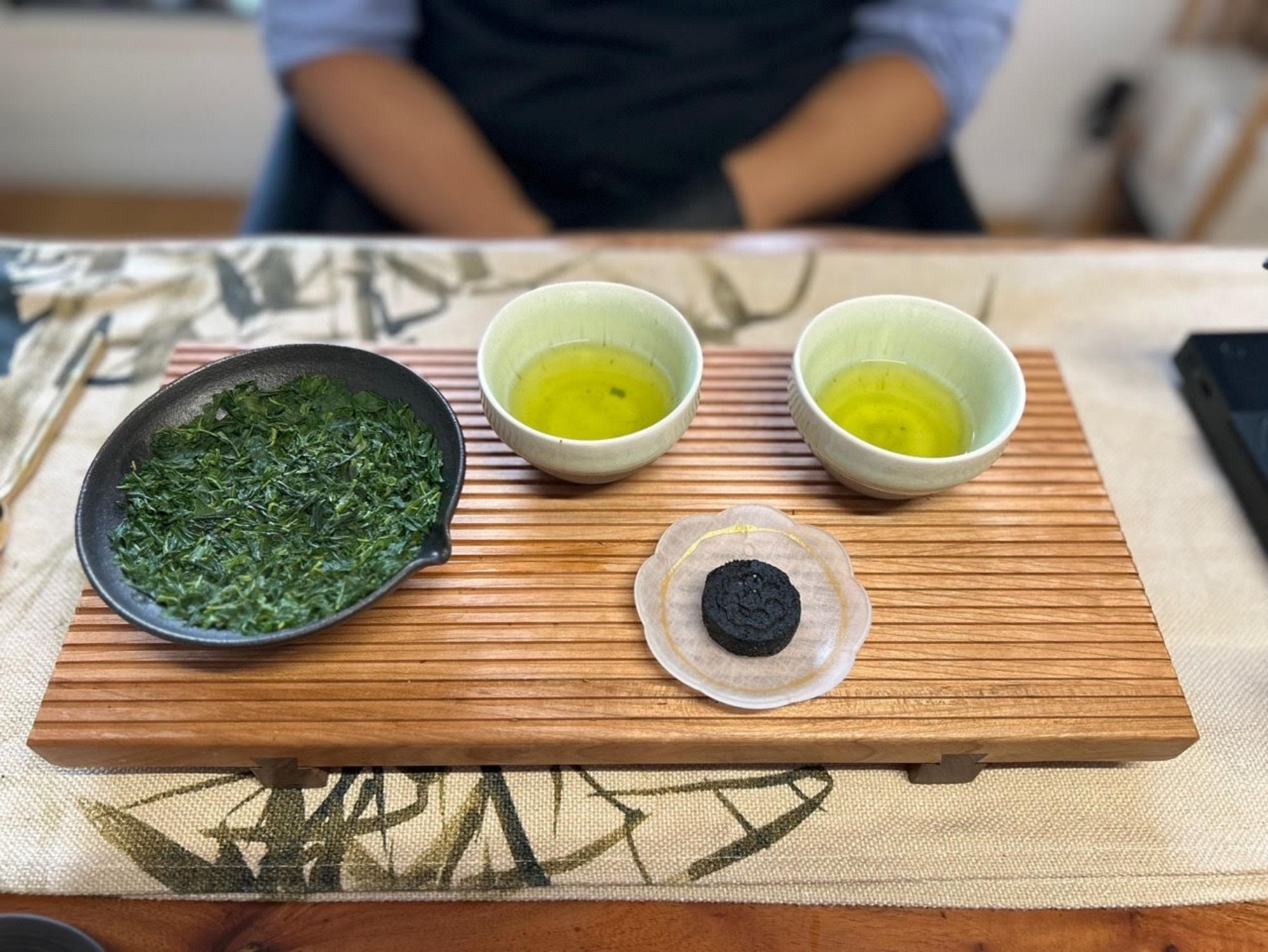 Cérémonie du thé : ingrédients de thé avec du thé vert frais et un excellent biscuit au thé sur une planche en bois.