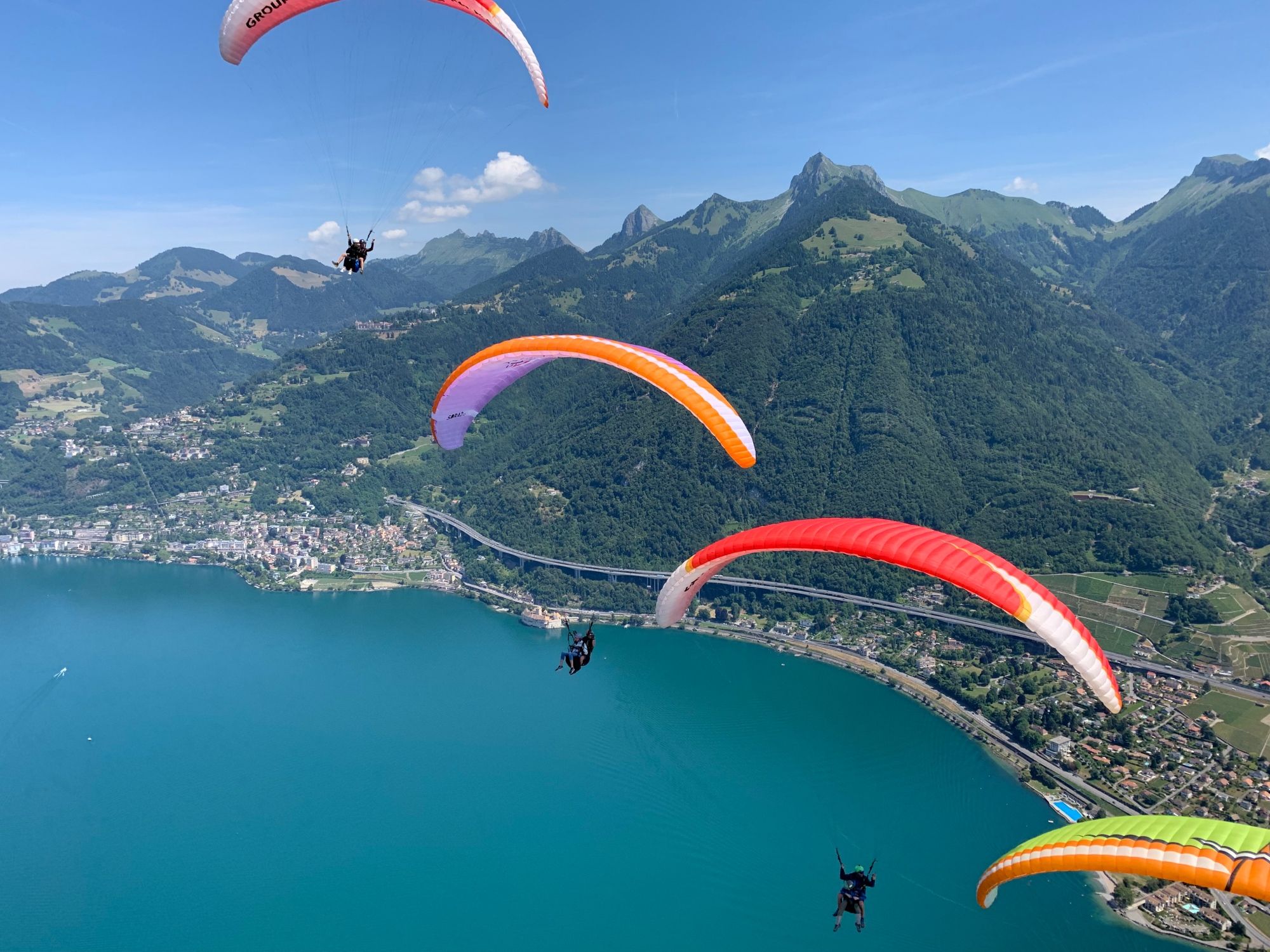 जेनيفا झील के ऊपर पैराग्लाइडिंग, पर्वतों और मनमोहक परिदृश्य के दृष्टिकोण के साथ।