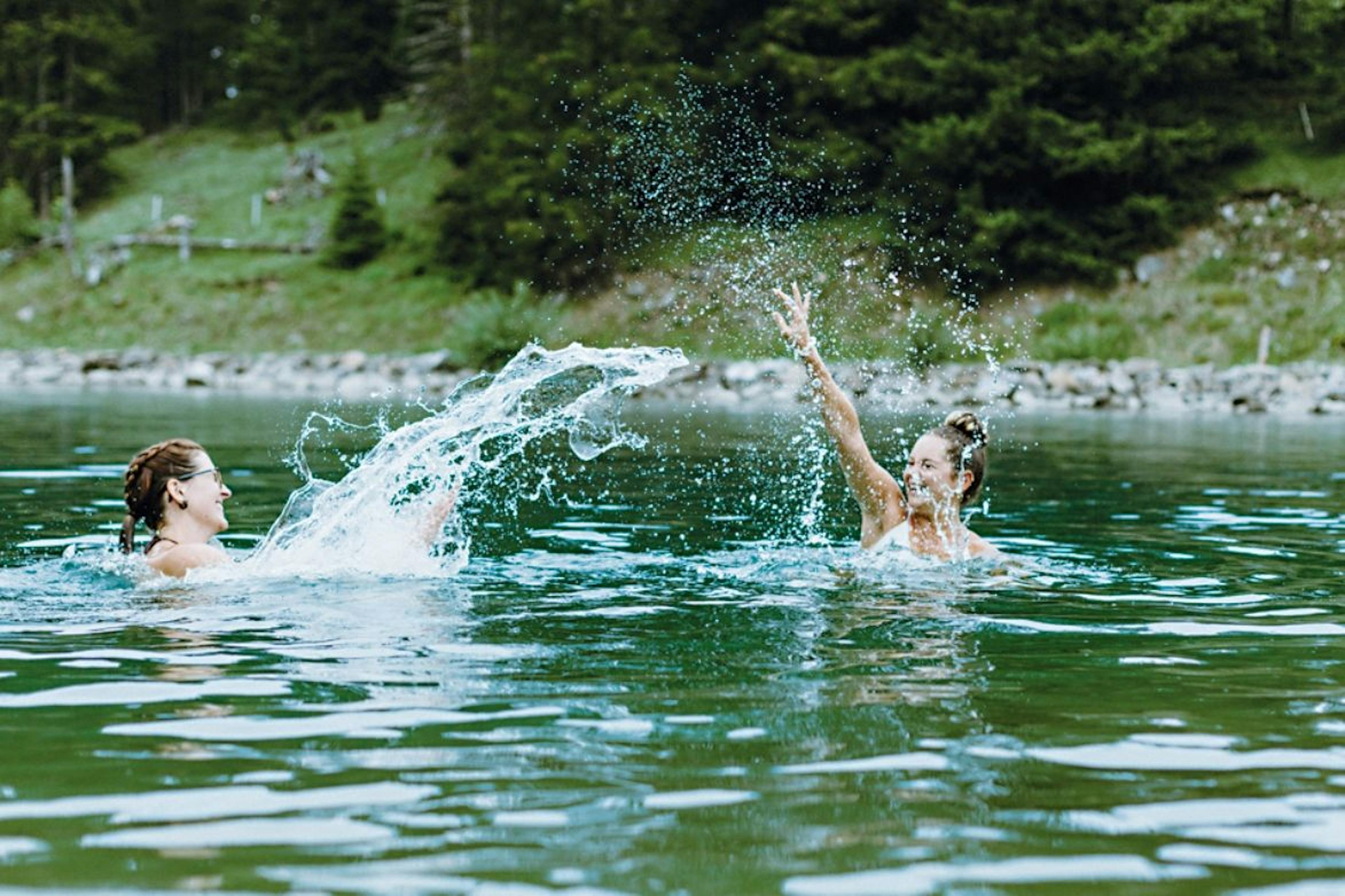 Brandsee Elsigen-Metsch, zwei Frauen spritzen Wasser im See, Sommer 2023.