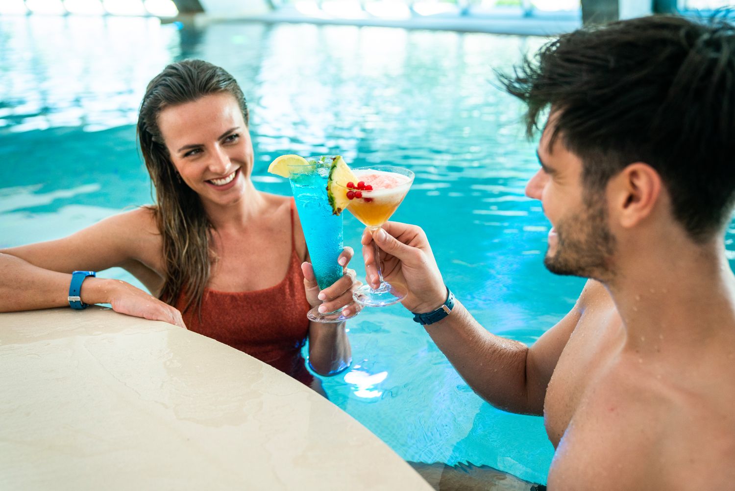 Μπαρ κοκτέιλ και ευεξία: Ένα ζευγάρι απολαμβάνει κοκτέιλ στην πισίνα.