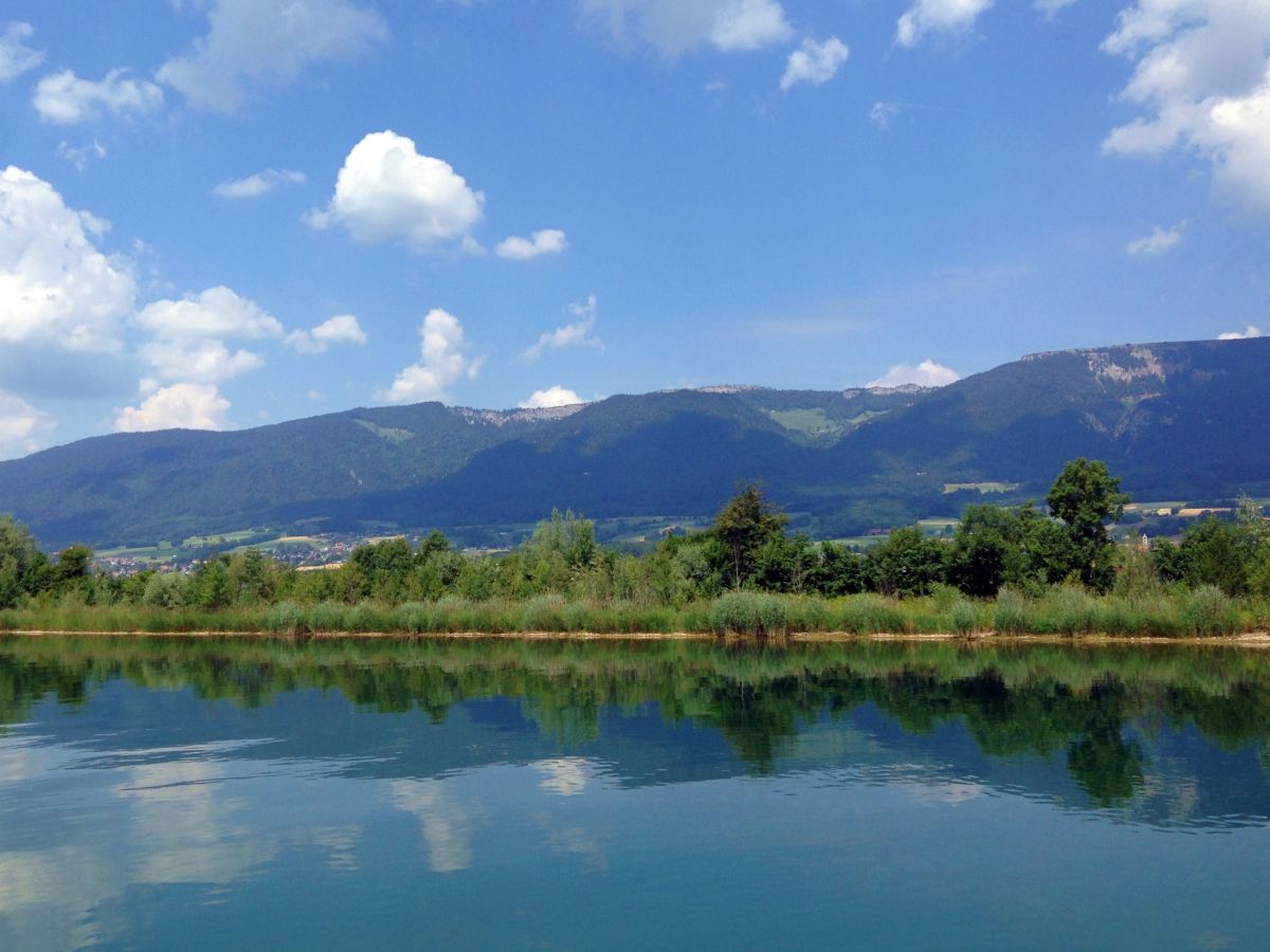 Aare: Vista sul lago tranquillo e le montagne circostanti in una giornata di sole estiva.