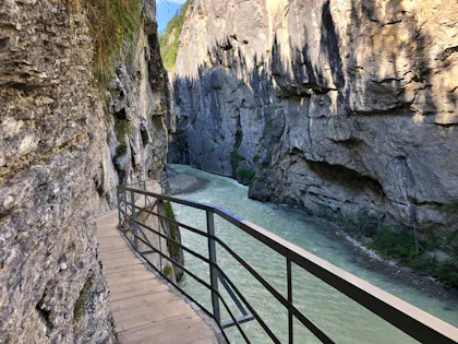 Aareschlucht: Wanderweg entlang der beeindruckenden Schlucht mit gruenem Wasser und steilen Felsen.